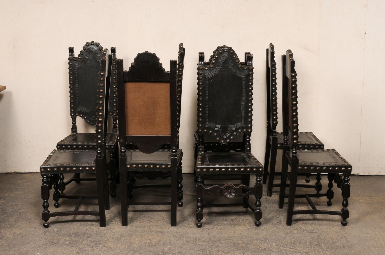 Ein spanischer Satz von acht Stühlen aus geschnitztem Holz und gepolstertem Leder aus der Mitte des 20. Diese mit barocken Einflüssen gestalteten Vintage-Stühle aus Spanien haben jeweils hochgewölbte Rückenlehnen, die von einem Paar geschnitzter