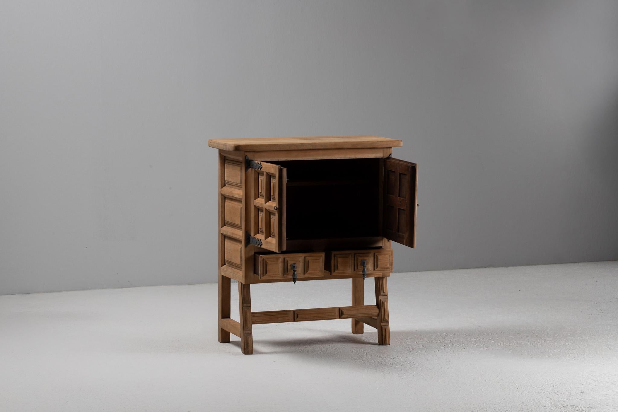 Ein rhythmisches Spiel von Schatten und Oberfläche belebt diesen bescheidenen und doch architektonischen Konsolenschrank, der aus massivem Ulmenholz gefertigt ist und auf einem gestreckten Sockel steht. Die Fassade ist durch tiefe, geometrische