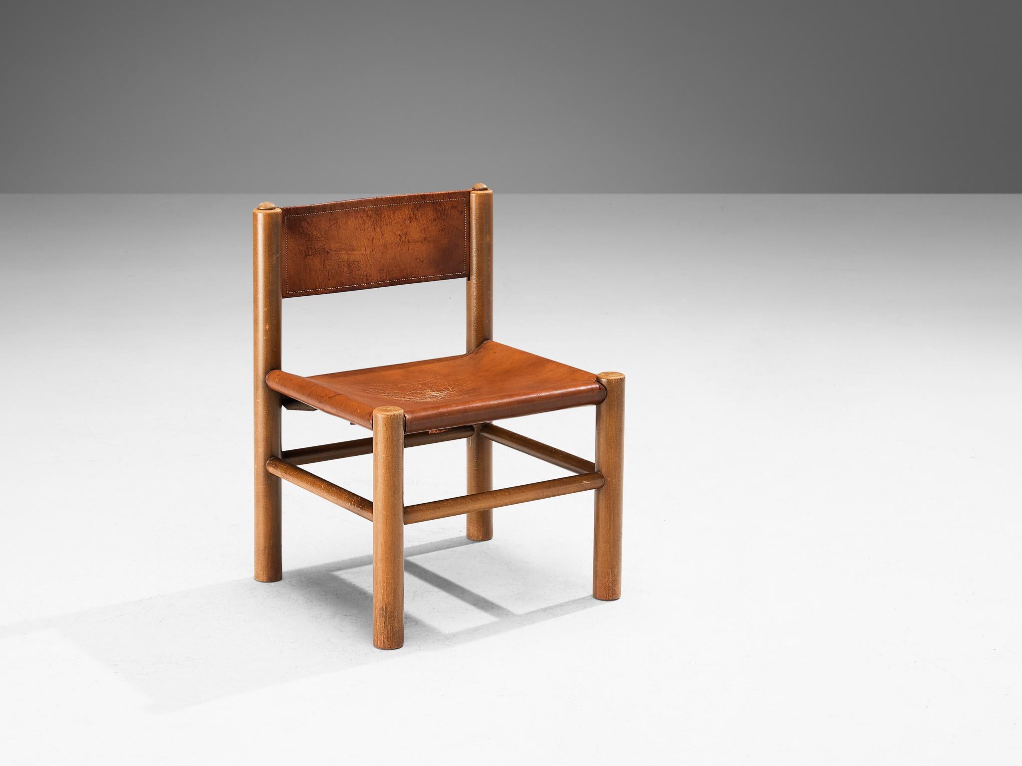 Side chair, stained beech, leather, Spain, 1960s

This strong and sturdy low chair is made in Spain. The thick brown leather forms the seat and backrest, providing an ergonomic quality. The wooden construction is comprised of cylindric slats