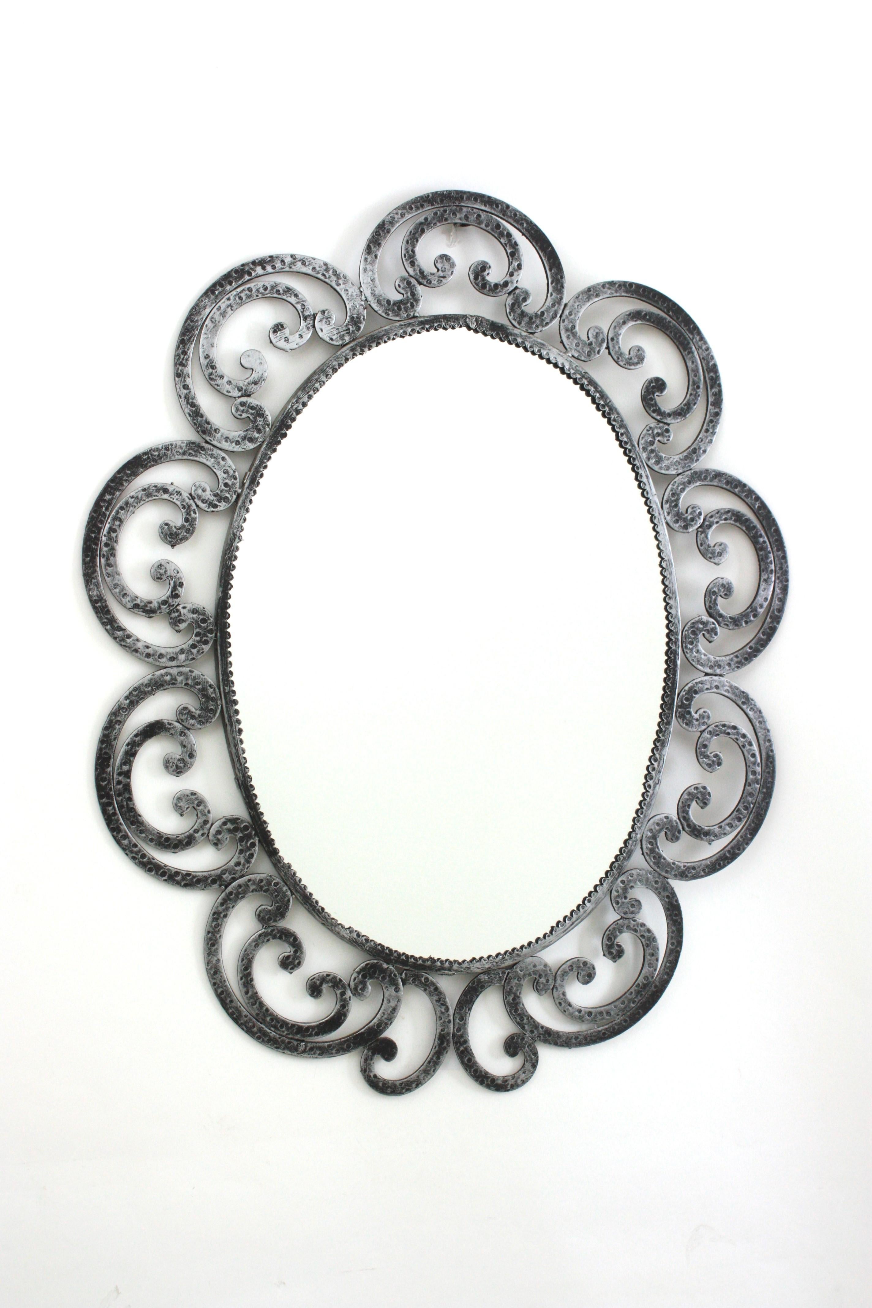 Large Silvered Oval Mirror, Wrought Iron
Wrought Iron Oval Sunburst Mirror with Scroll Details and Brutalist Design, Spain, 1950-1960.
Eye-catching hand forged iron mirror with scroll decorations as flower petals and oval shape.
This beautiful oval