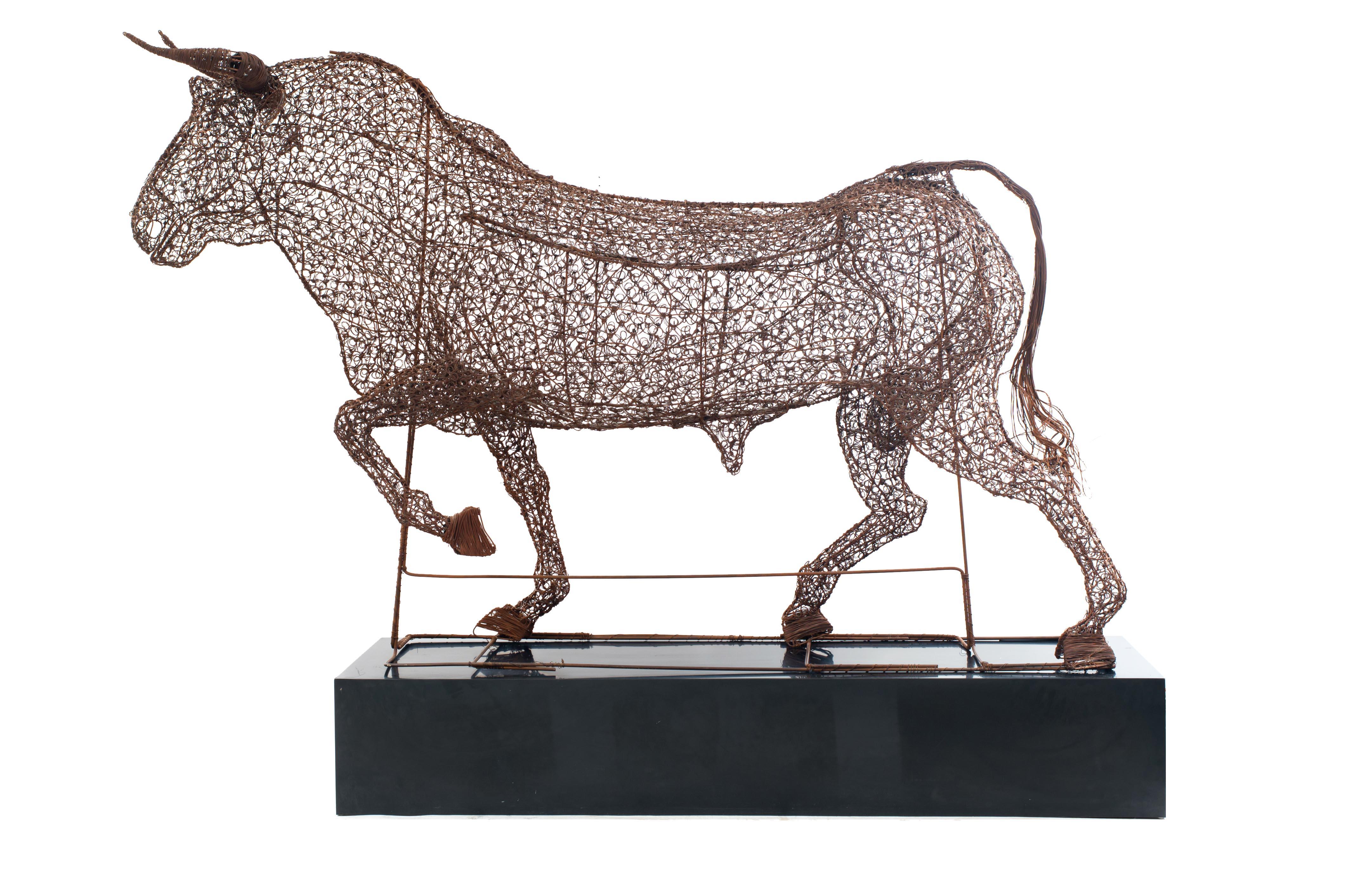 Spanish-style life size wire bull figure resting on a black plinth (1950s).
