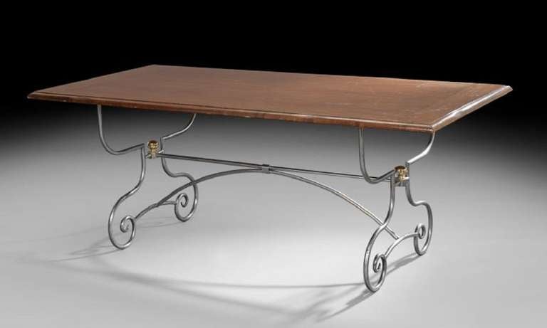 Early 20th century Spanish-style mahogany and silvered metal guard room table, the rectangular top with molded edge, raised on shaped and scrolling tubular end supports joined by stretchers and ending in scrolled feet.