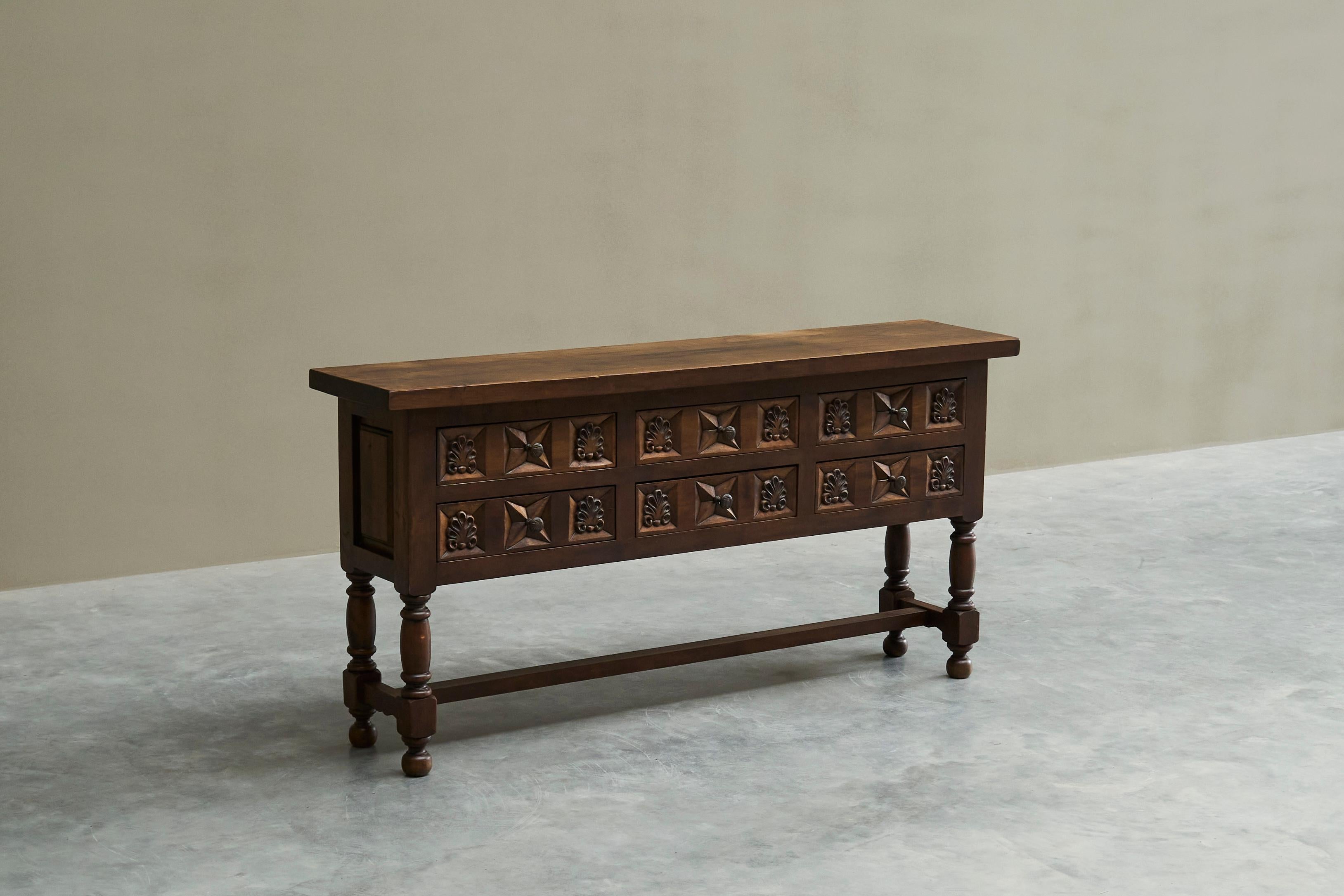 Spanish Style Sideboard in Hand Carved Solid Walnut and Wrought Iron, Europe, Early 20th Century.

A stunning Spanish style sideboard / console table with drawers in carved solid walnut and wrought iron details. Late 19th century or early 20th