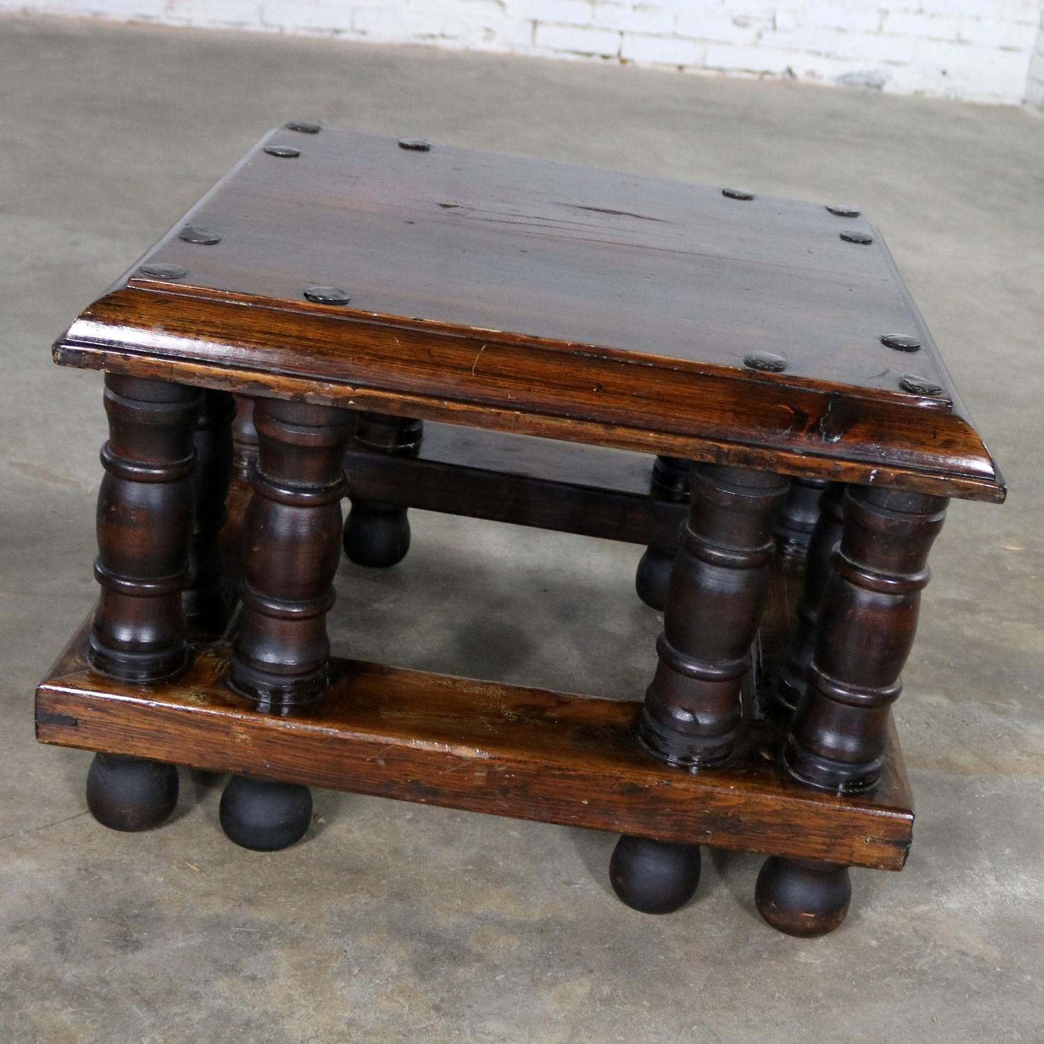 Wonderful Spanish Revival style square end or side table by Artes de Mexico Internacionales, SA. It is in fabulous vintage condition with hand-hammered metal extra large nailheads, turned legs, and lots of age patina with its original tag, circa