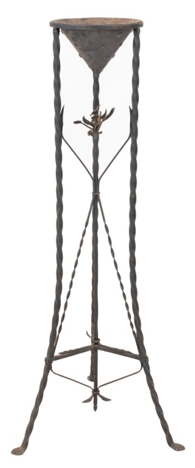 Spanish style wrought iron pant stand, of tripodal form, with conical stand supported by three twisted wrought iron supports conjoined by cross-spindles supporting a center shaft decorated with flowers. 54