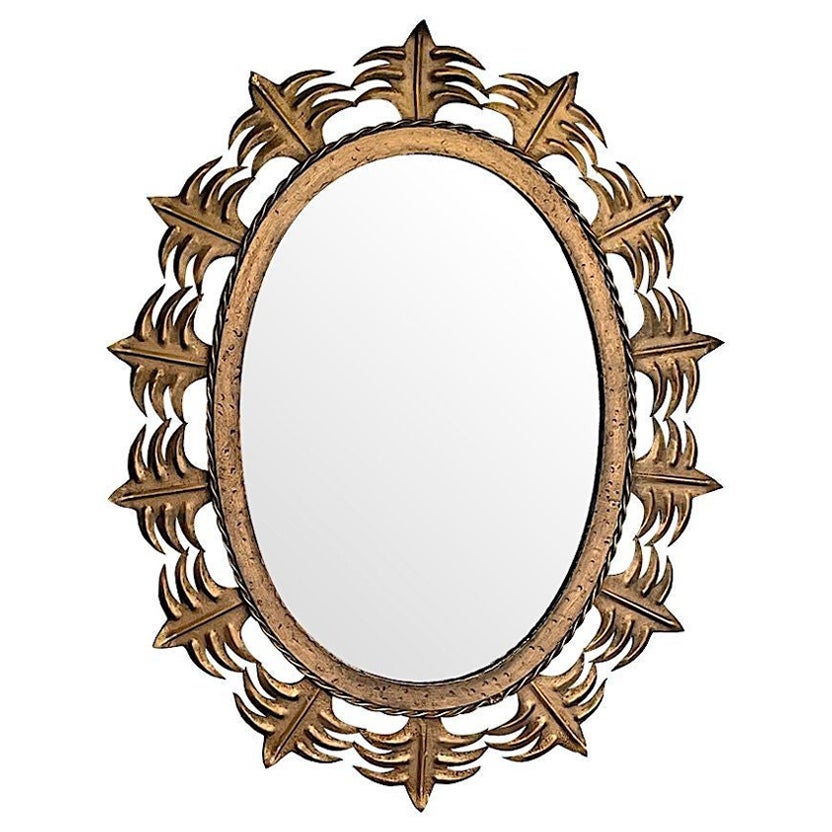 Miroir ovale espagnol en métal doré en forme de soleil des années 1950 avec bordures ornées. en vente