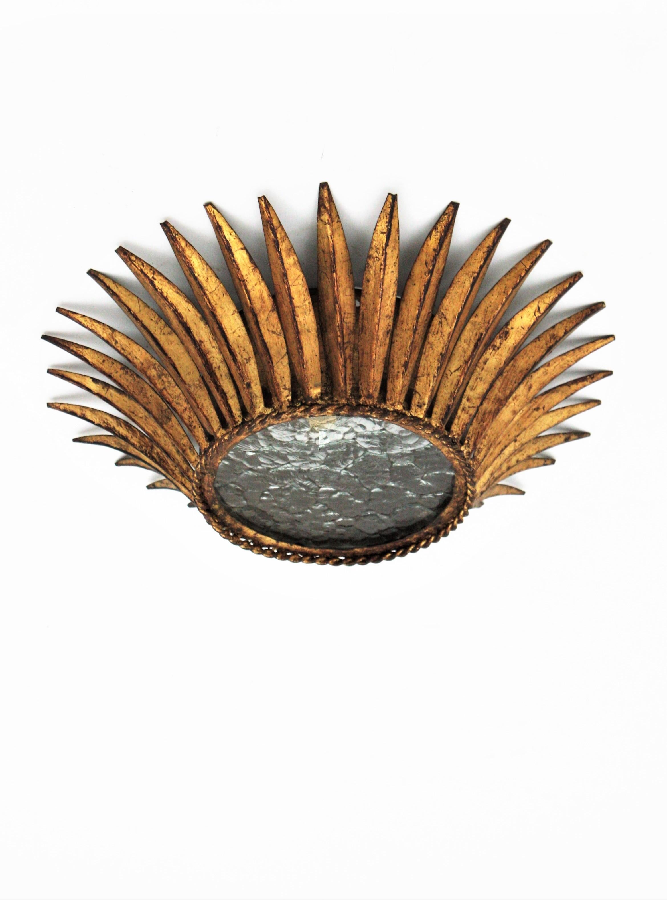 Monture de chasse en forme de couronne forgée à la main, fer doré, verre texturé, Espagne, années 1950.
Un élégant luminaire en forme de couronne ou un montage encastré en bronze doré avec un difusser en verre clair texturé. Il n'y a qu'une seule