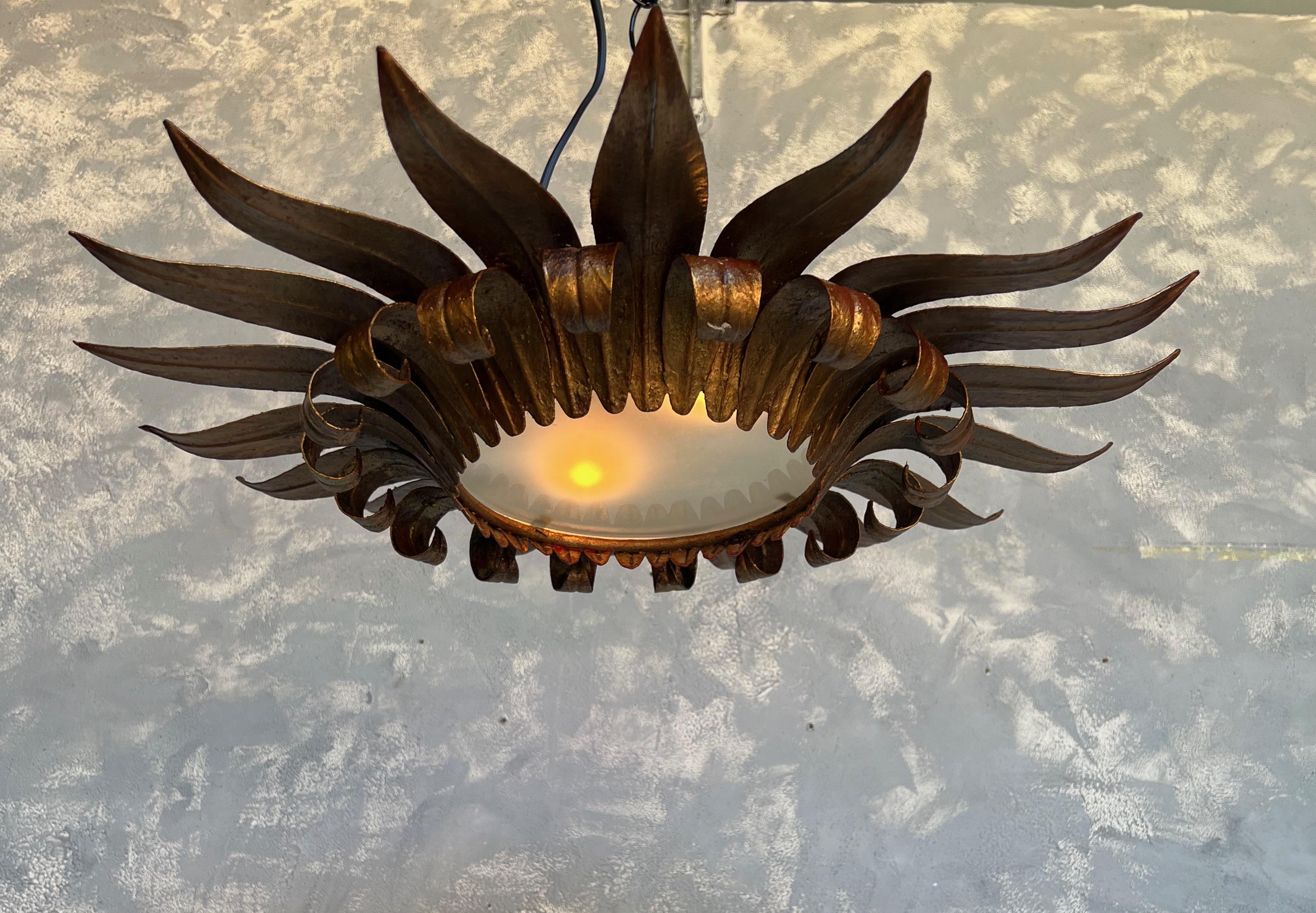 This intriguing Spanish flush mount ceiling fixture is a remarkable piece of craftsmanship with a double tiered leaf design. The upper leaves primarily lie flat, offering a contrast to the lower leaves which curve gracefully at the top and extend