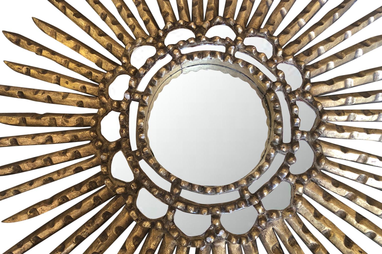 A very beautiful early 20th century hand carved wood sunburst mirror in giltwood.