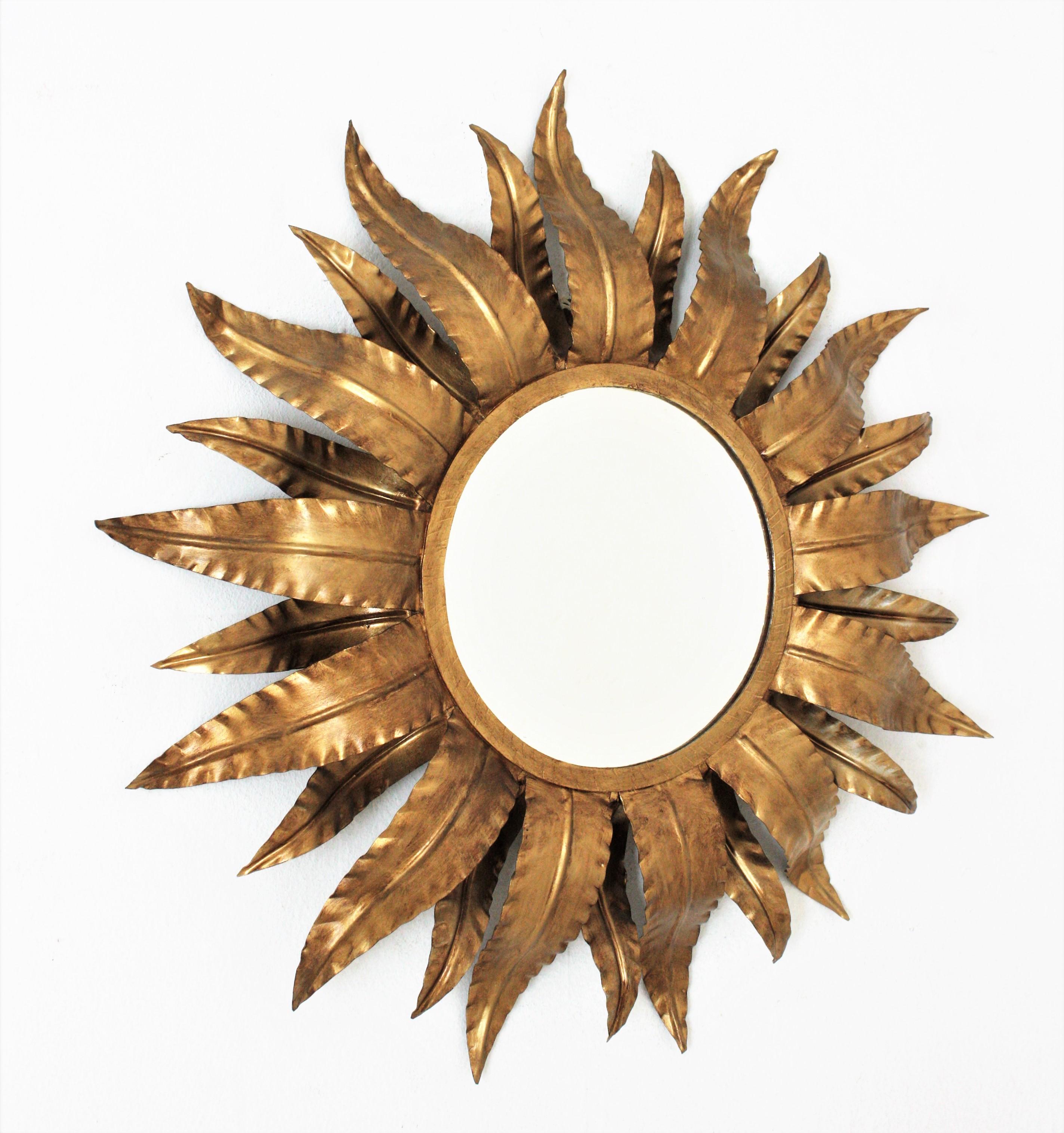 Mid-Century Modern double layered sunburst wall mirror, Spain, 1960s
This eye-catching foliage sunburst mirror features a double layer of leaves surrounding a central round glass.
It has a beautiful patina and original finish in bronze-gilt