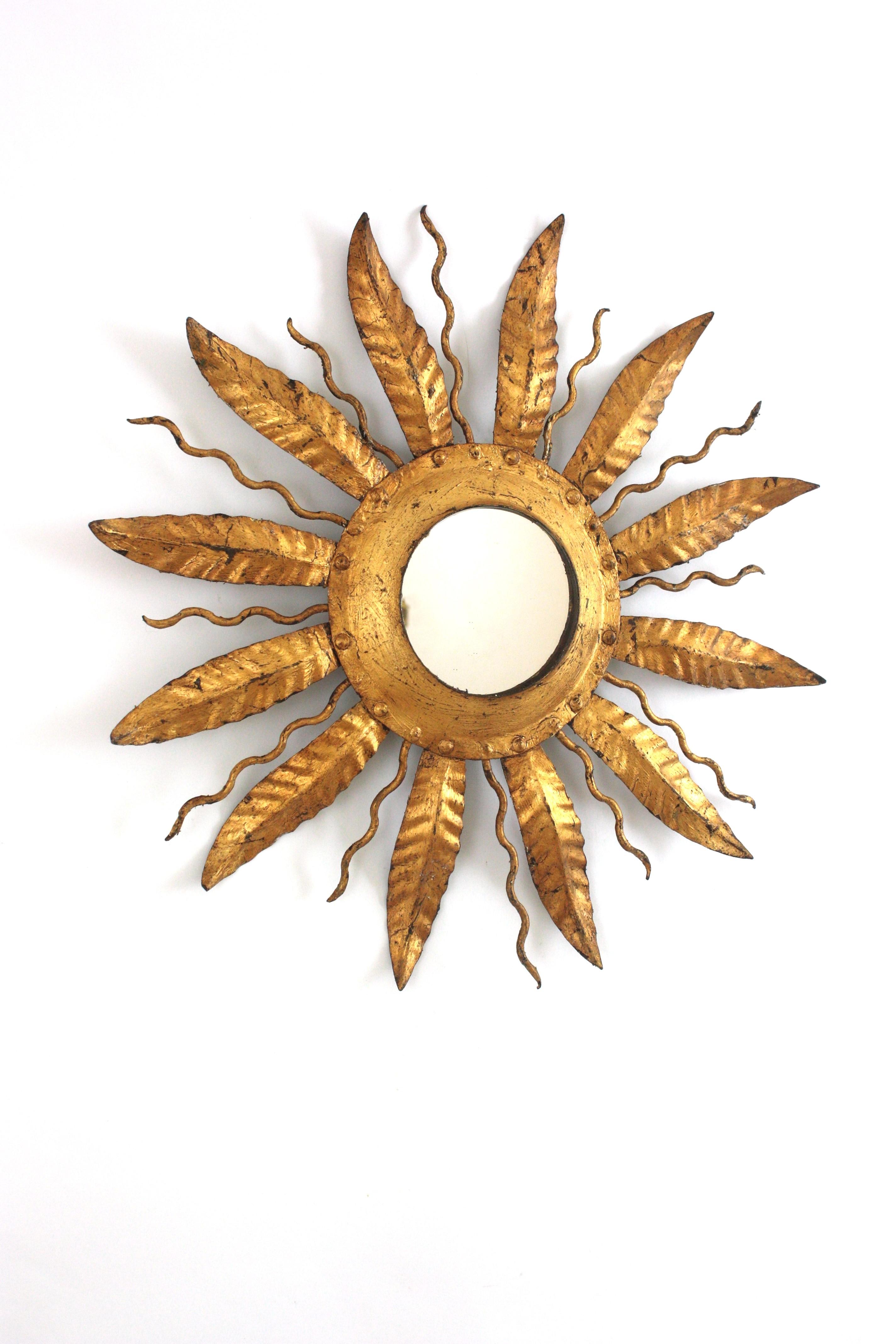 Accattivante montatura da incasso a raggiera con foglie di metallo dorato. Spagna, 1950-1960.
Questa plafoniera a incasso presenta una struttura in ferro con un pannello centrale rotondo circondato da foglie alternate e raggi ricci.
Il pannello