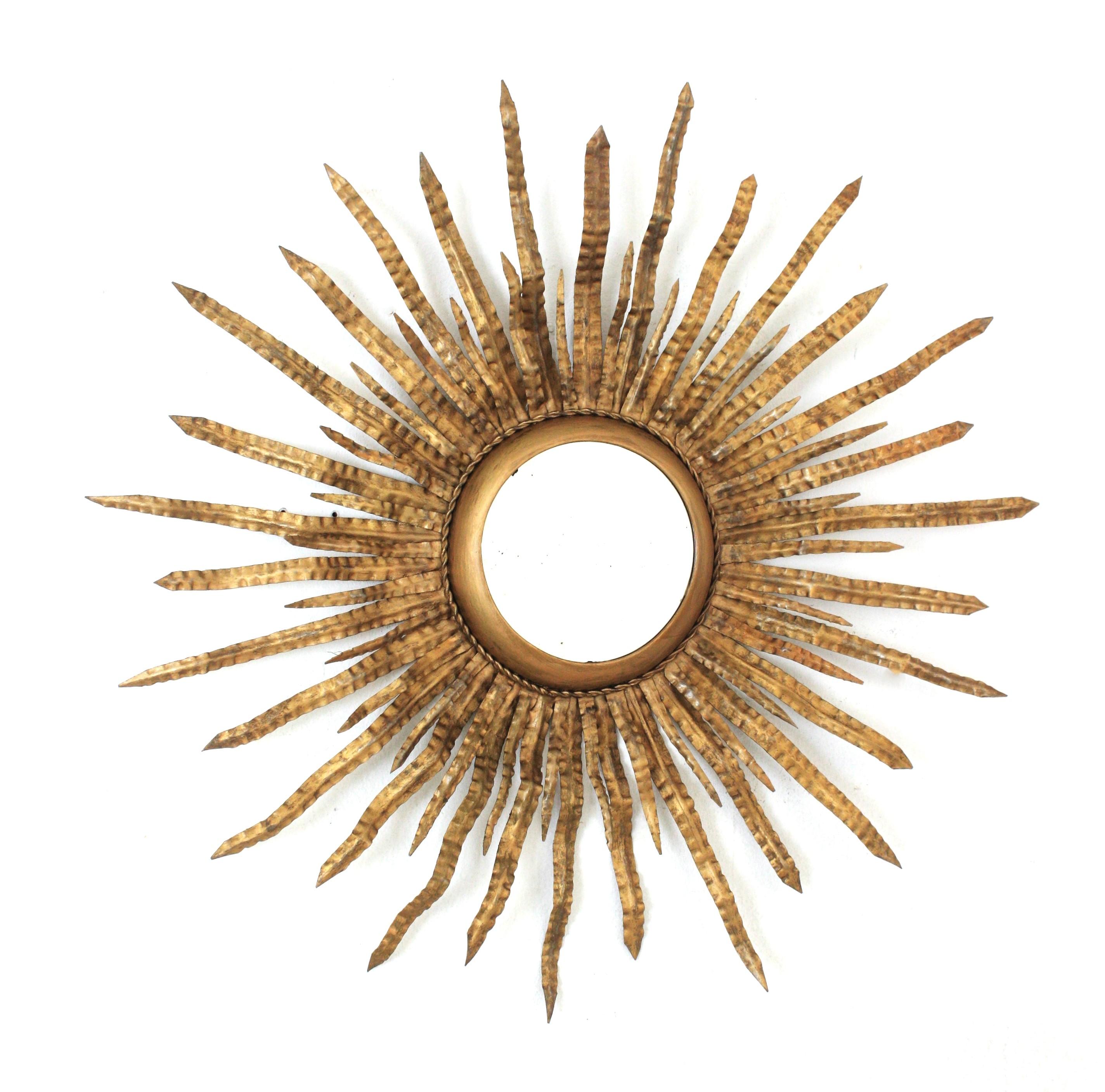 Large Sunburst Starburst Mirror, Gilt Metal
Mid-Century Modern double layered sunburst wall mirror, Spain, 1960s
This eye-catching foliage sunburst mirror features a double layer of thin leaves, surrounding a central round glass. The leaves are full