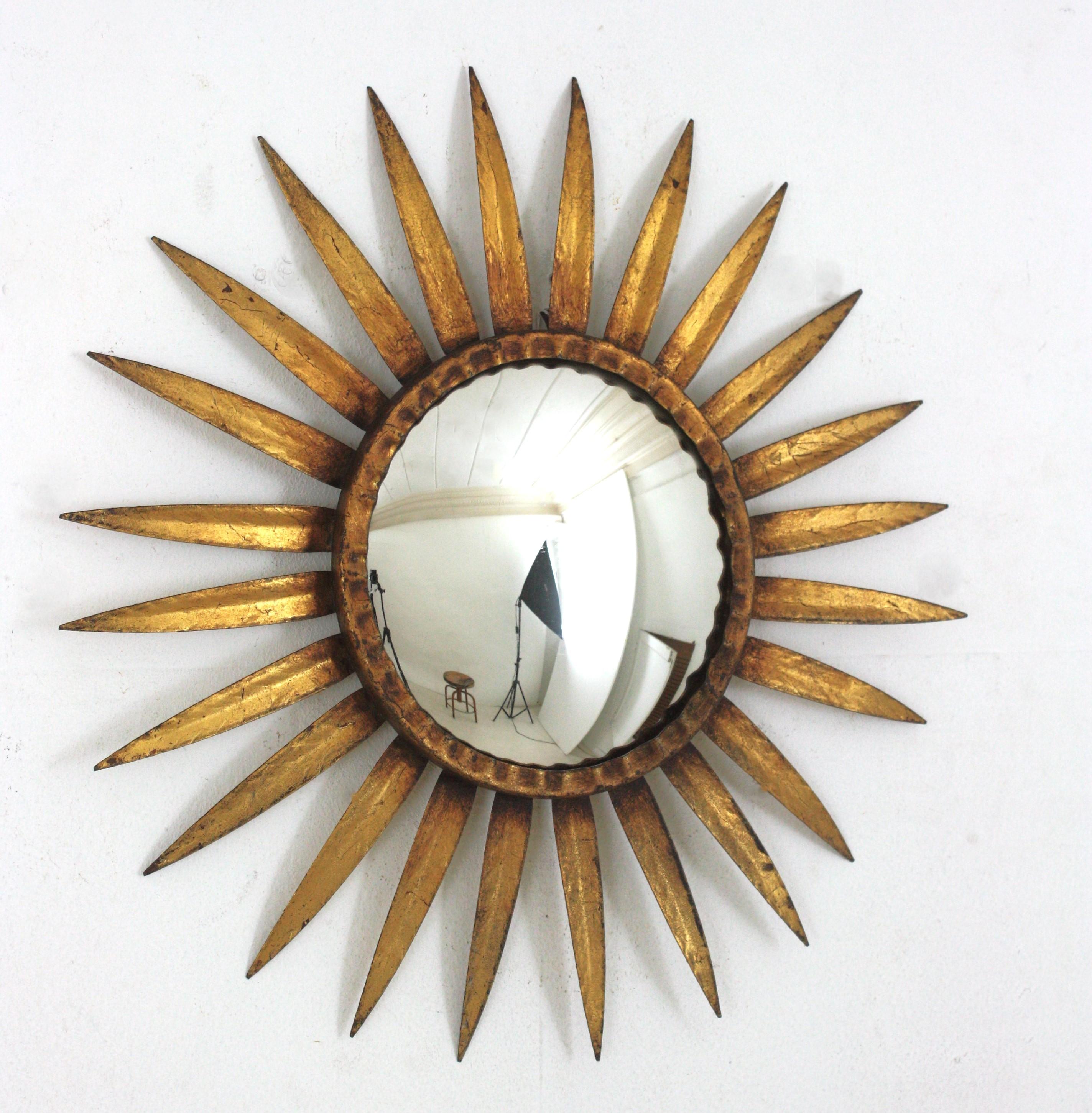 Convex Sunburst Mirror, Iron, Gold Leaf
Eye-catching Mid-Century Hollywood Regency sunburst mirror in gilt wought iron, Spain 1950s
Convex glass and gold leaf gilding. It has a terrific aged patina showing its original gilding.
Gorgeous placed alone