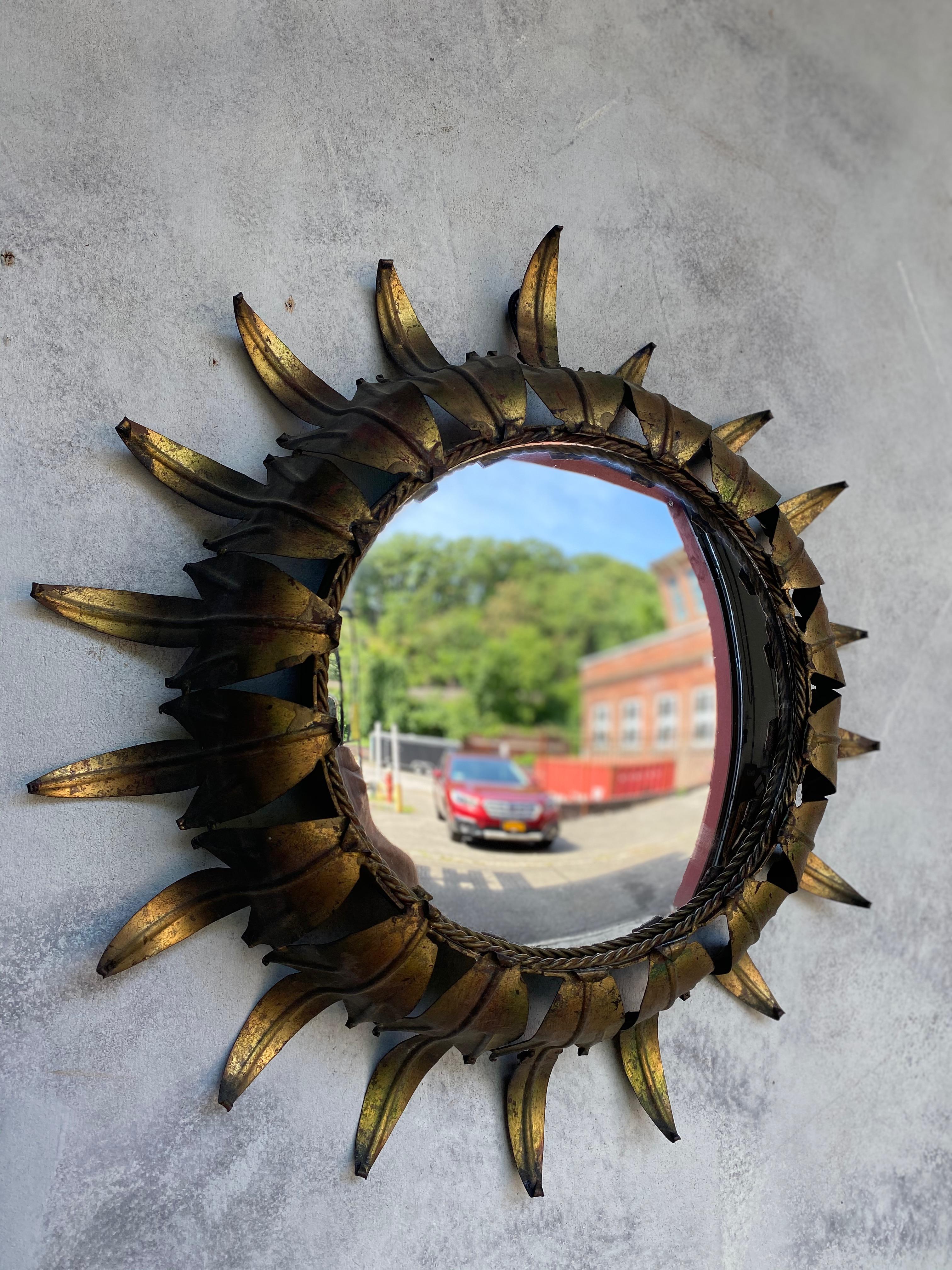 1950s Spanish gilt metal sunburst with convex mirror and a braided border. We recently added a felt backing to the mirror to give it more protection and a finished look. Very good vintage condition. 
