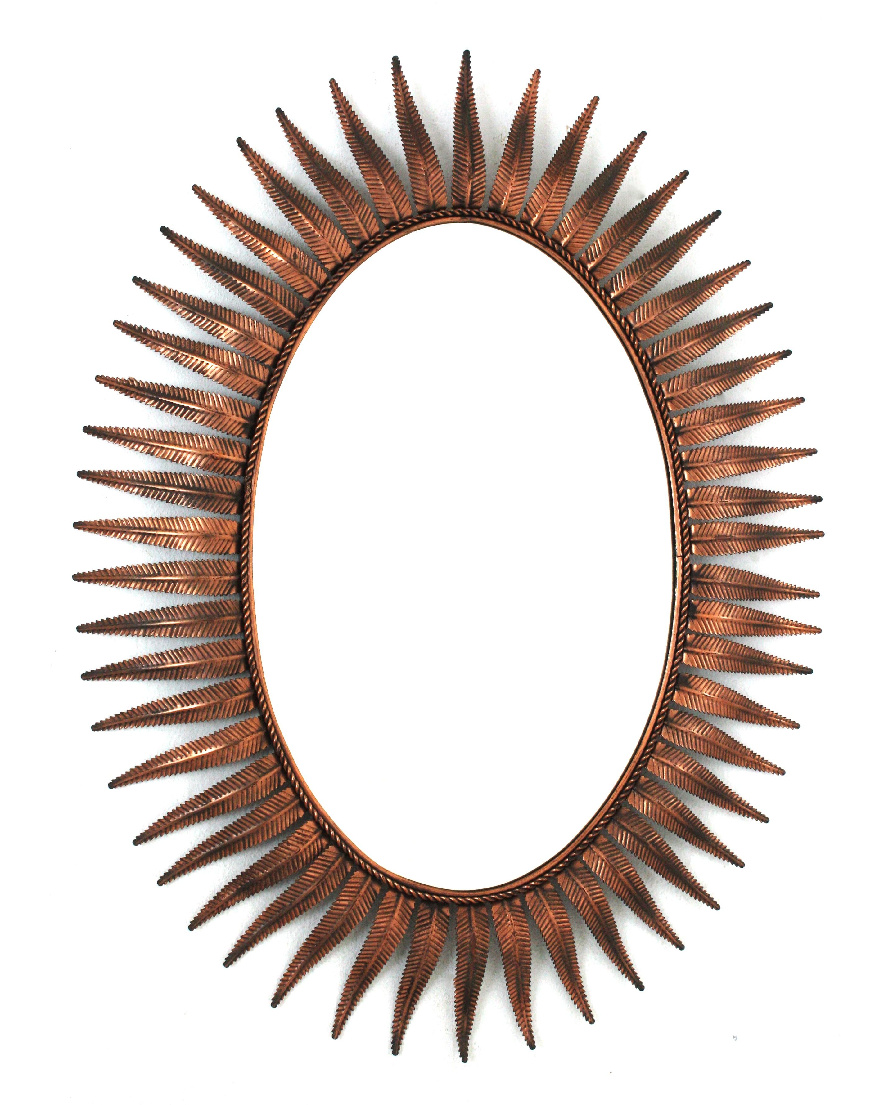 Large Oval Sunburst Starburst Mirror, Iron, Gopper Metal
Mid-Century Modern leafed sunburst wall mirror, Spain, 1960s
This eye-catching foliage sunburst mirror features a layer leaves in coppered metal surrounding a central oval glass. The leaves
