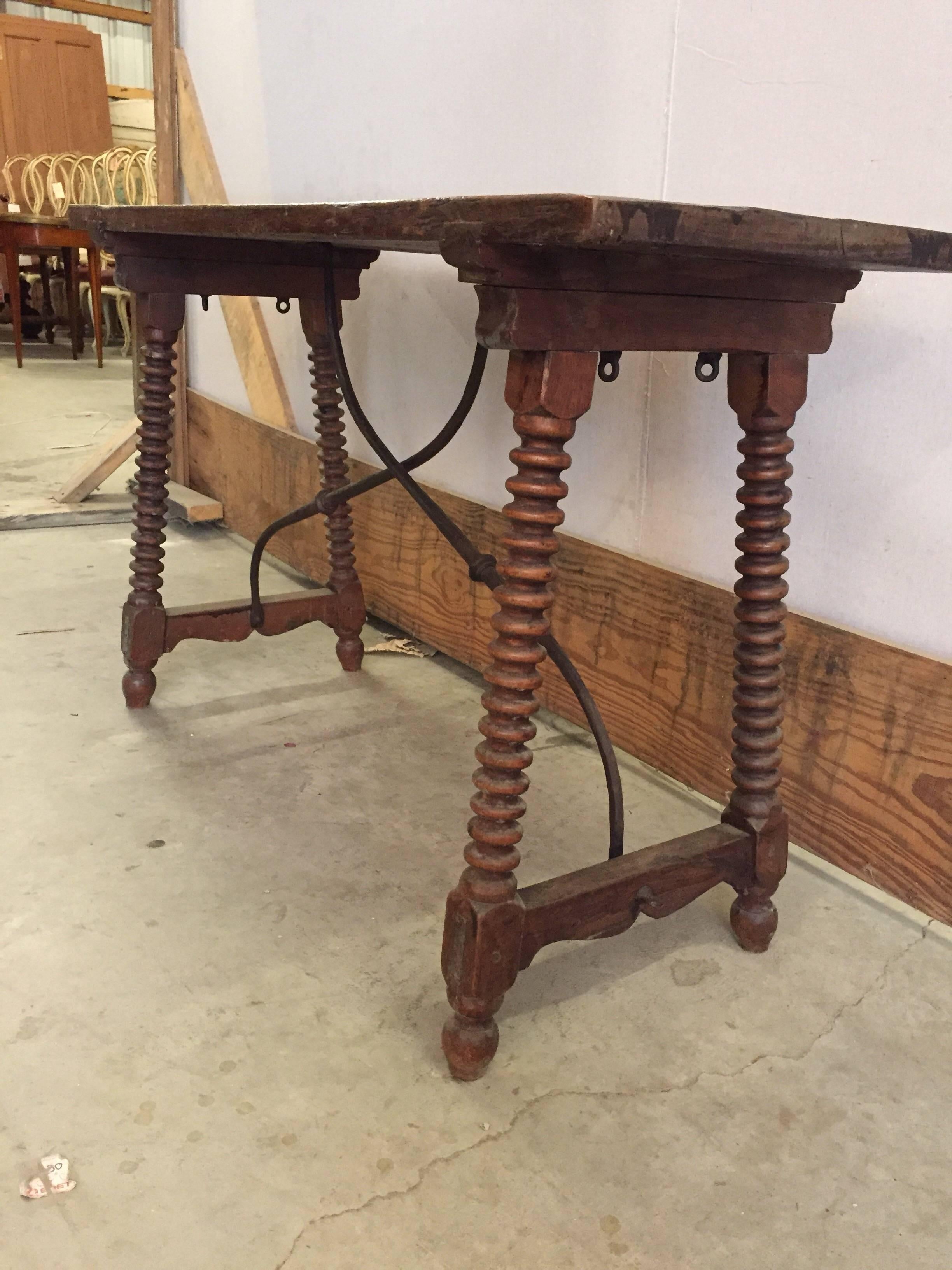 Walnut and wrought iron strap table with solid walnut top. Beautiful carved bobbin style legs, beautiful wrought iron stretchers.