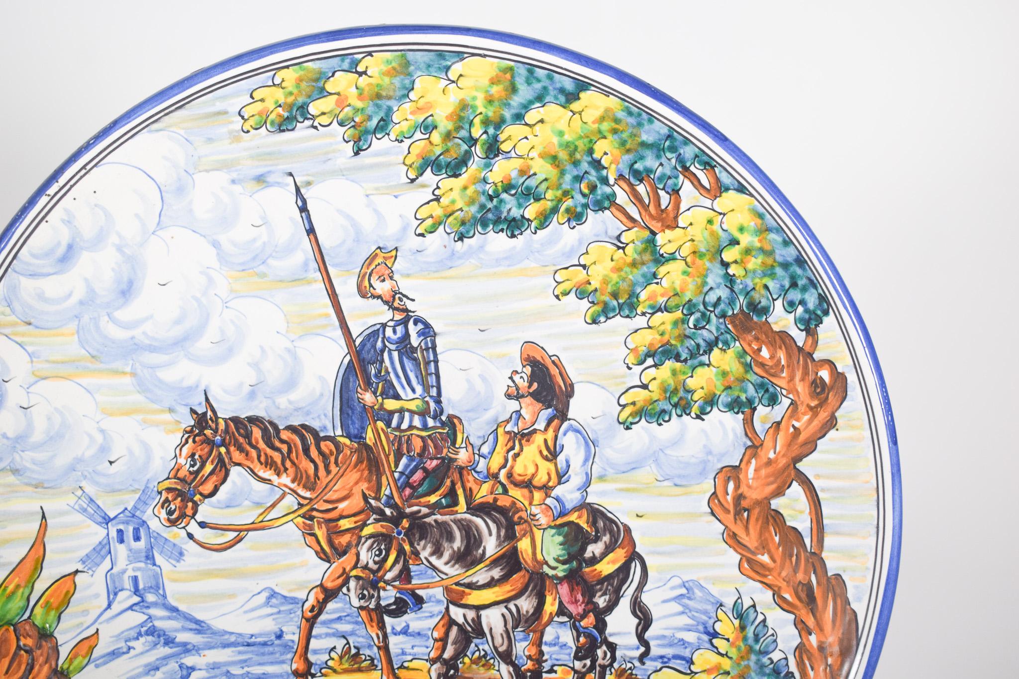 Assiette en faïence espagnole Talavera. Cette assiette en céramique présente une scène détaillée inspirée de l'œuvre littéraire emblématique de Miguel de Cervantes, 