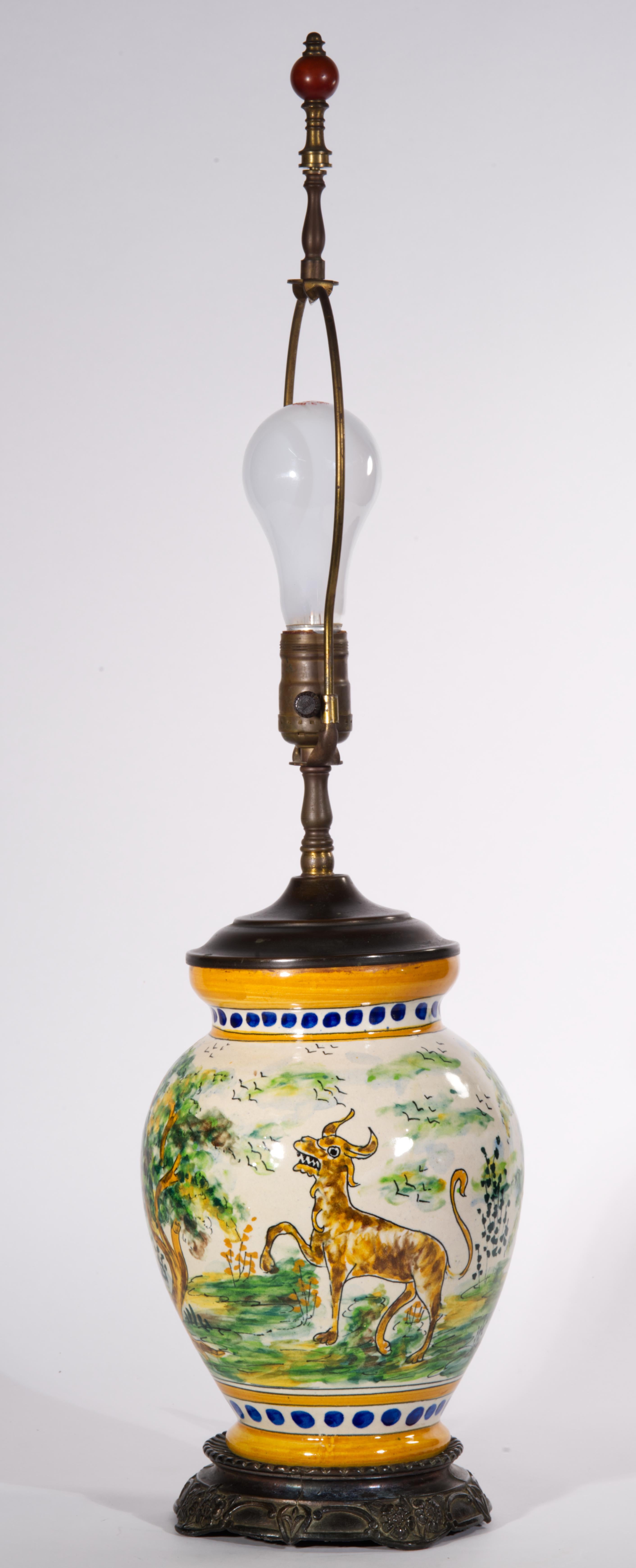  Striking urn table lamp features antique or vintage Talavera ceramic vessel converted into lamp base. The urn is decorated with the characteristic hand-painted Talavera de la Reyna motifs of colorful country landscape with tall trees and flocks of