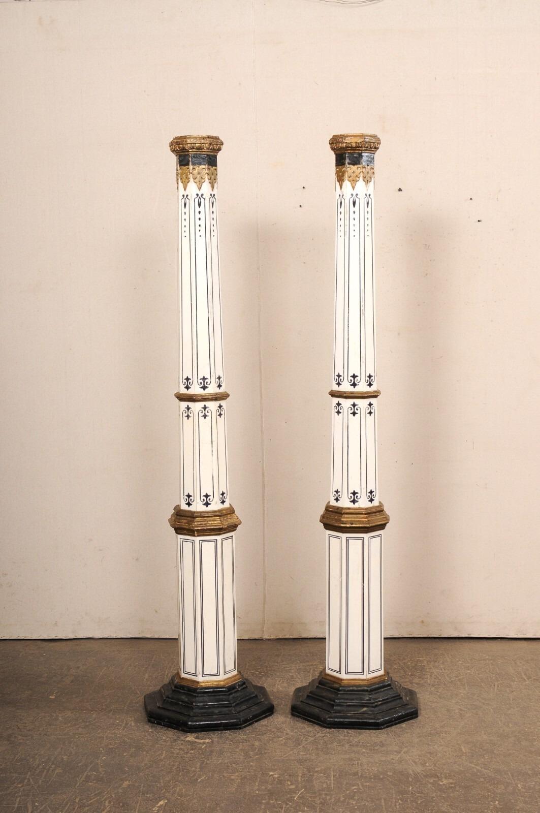 A Spanish pair of tapering, painted wood columns from the early 20th century. This tall pair of antique pillars from Spain, each with a hand-painted, decorative finish, have octagonal-shaped and tapering bodies, with egg and dart trim about their