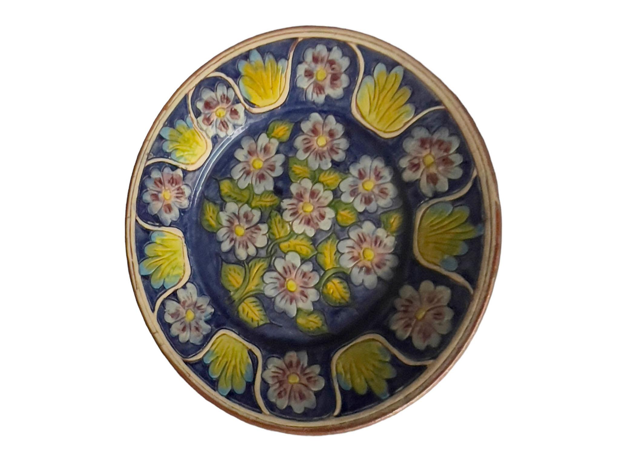 Vintage terracotta plate with a blue and yellow floral design from Spain. Circa 1960s.