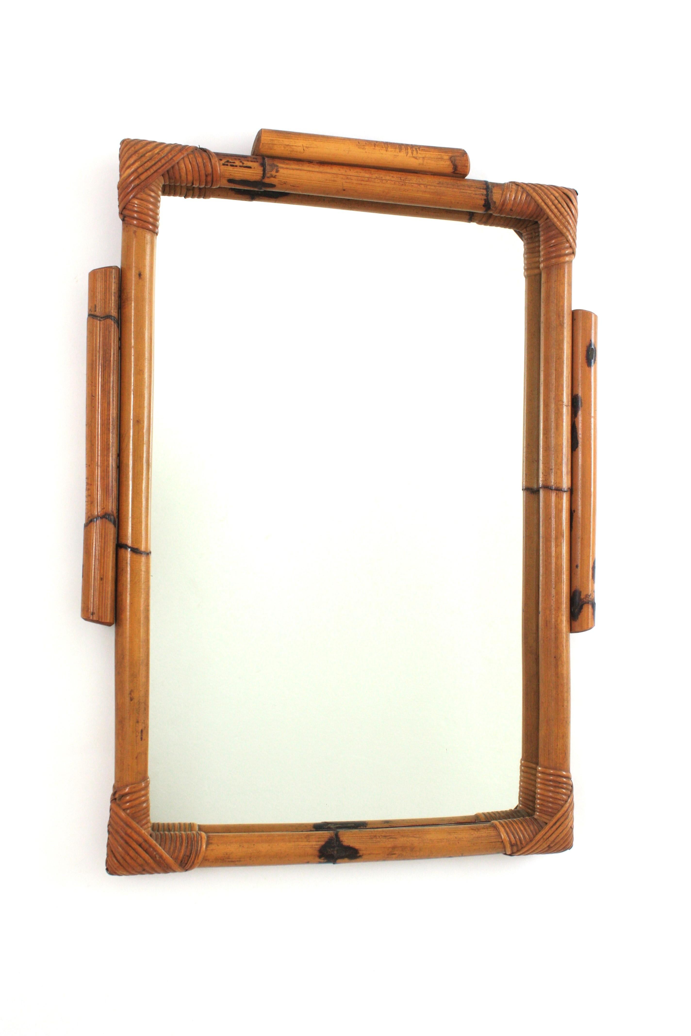Specchio da parete rettangolare in bambù e rattan in stile Tiki spagnolo del Mid-Century Modern. Spagna, anni '60.
Splendido specchio rettangolare in stile Tiki realizzato a mano con canne di rattan. Ha una cornice molto decorativa con decorazioni