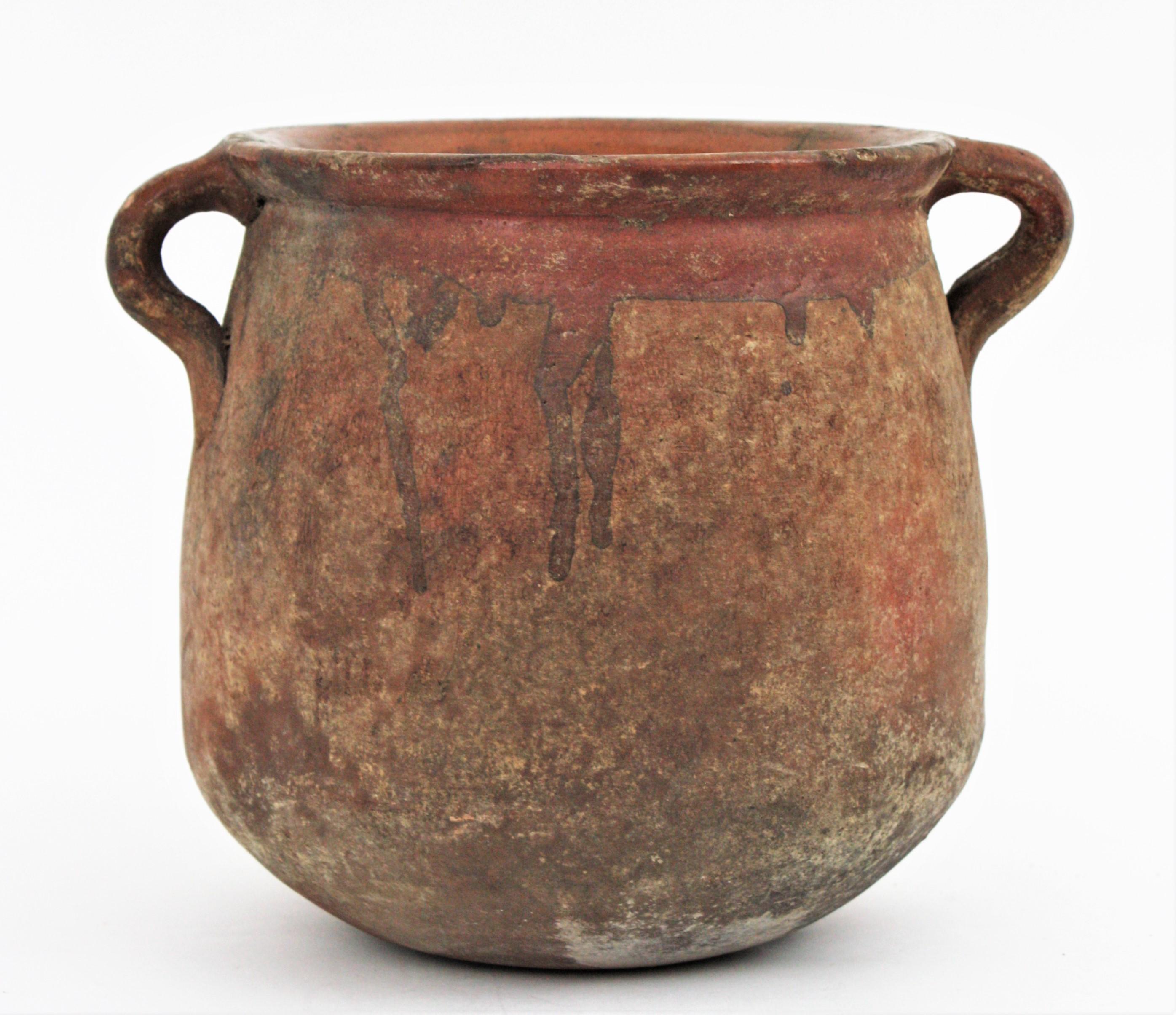 Handmade terracotta preserving pot with handles from Catalonia. Spain, 19th century.
Traditional catalan spanish ceramic 'olla'. Unglazed exterior with handles at both sides and glazed interior to preserve food. Dramatic antique patina.
Use it as