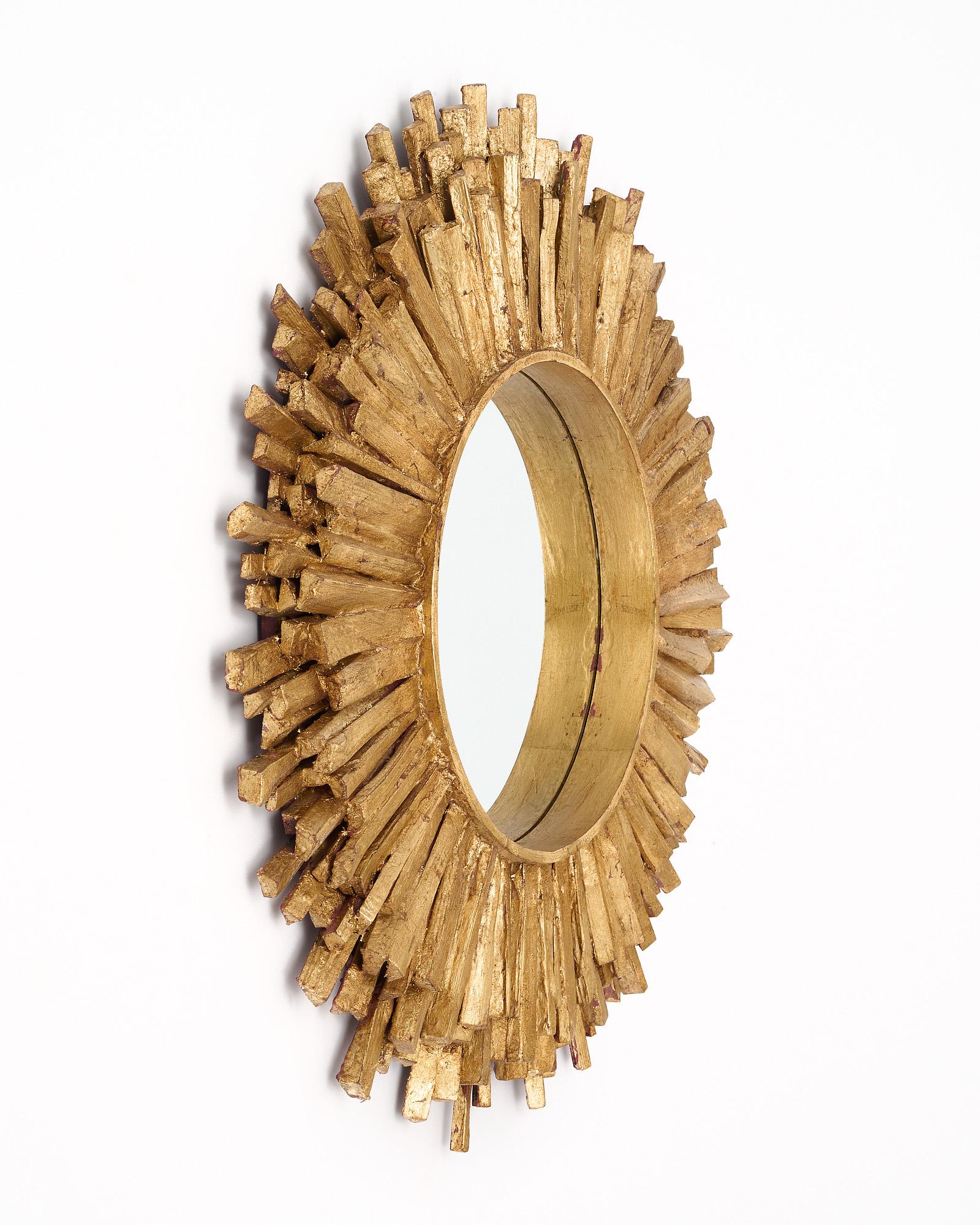Sunburst mirror from Spain with a circular central mirror and gold-leafed rays emanating outwards to form a striking sunburst effect. This highly decorate pieces is quite effective.