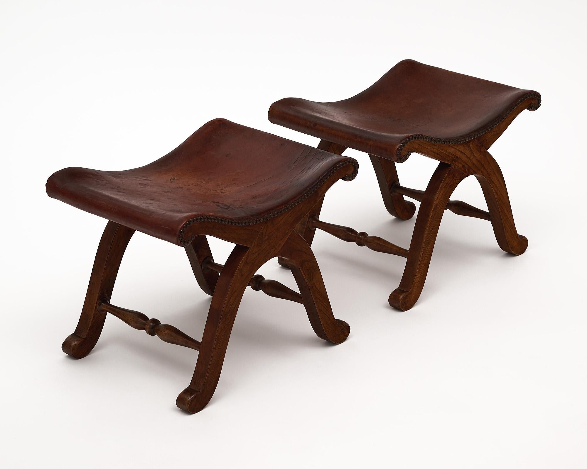 Pair of curule stools, Spanish, made of solid oak and patinated leather. This pair is by Valenti.
