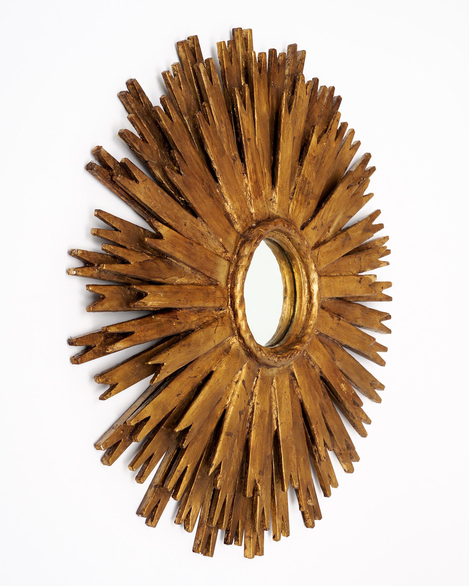 Sonnenschliffspiegel aus Spanien aus handvergoldetem Holz. Die Strahlen gehen von einem kreisförmigen zentralen Spiegel aus. Der Spiegel ist in schönem Vintage-Zustand mit nur geringen Oberflächenabnutzungen, die dem Alter und dem Gebrauch