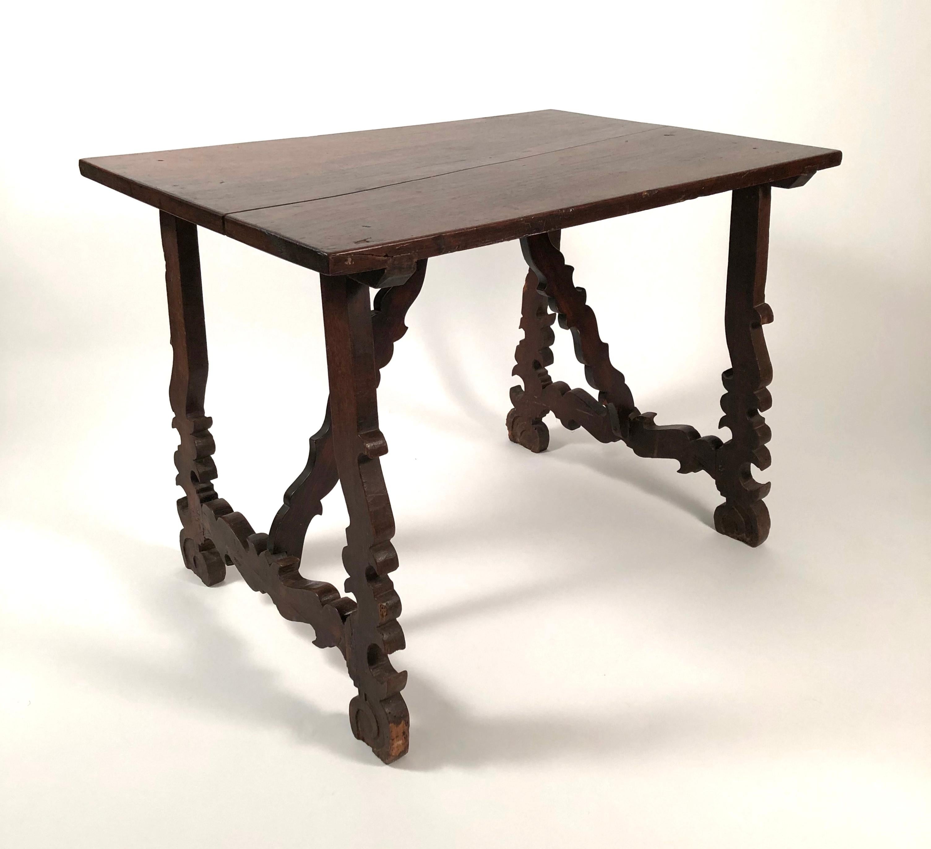 A Spanish walnut Baroque style table, 19th century, with earlier elements, the, single plank rectangular top, supported by shaped legs joined by cross stretchers. Wonderful, sculptural form.
  