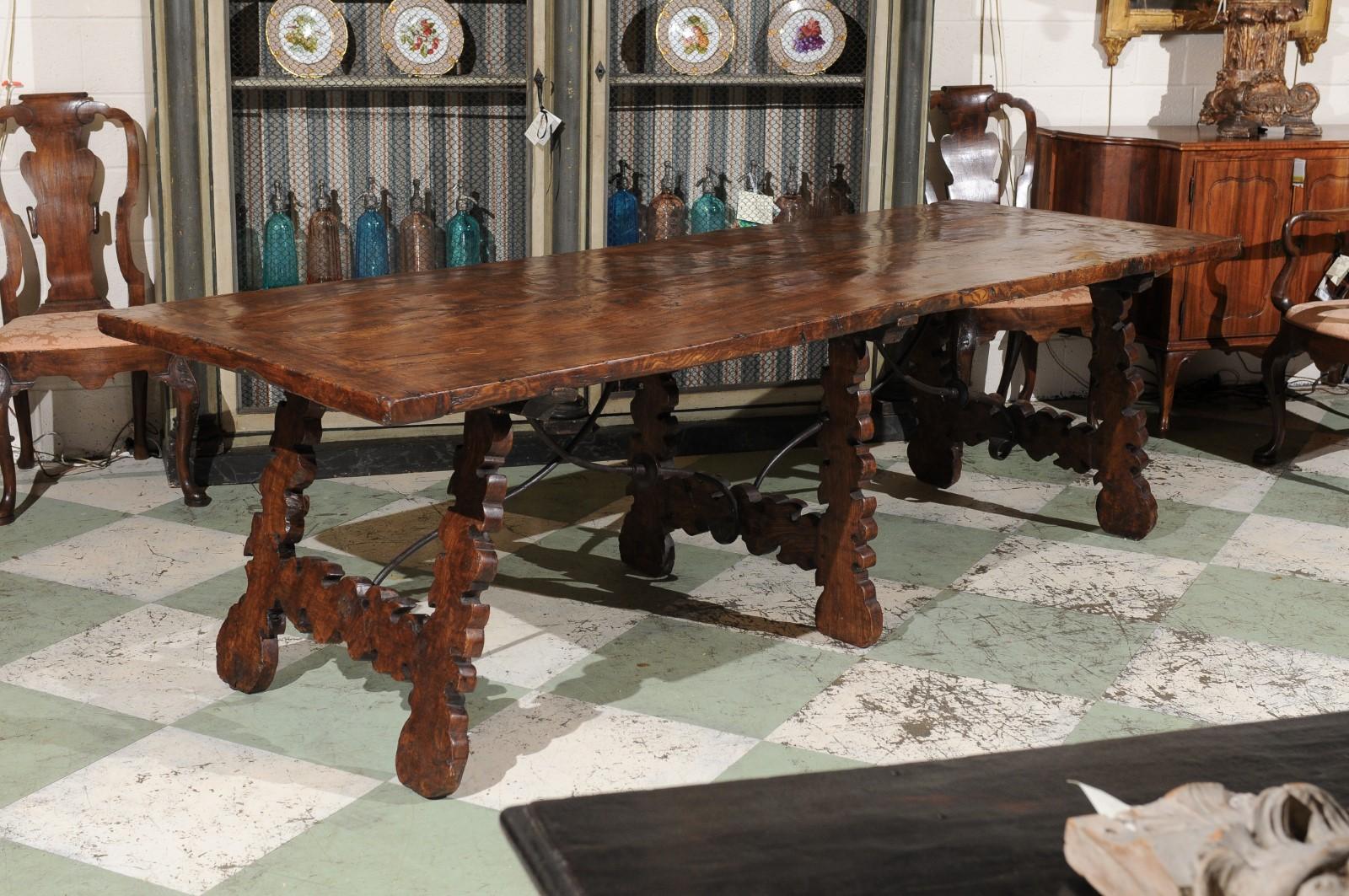 Table de salle à manger en noyer espagnol avec des pieds en forme de lyre et un châssis en fer forgé. Reproduction faite à la main.