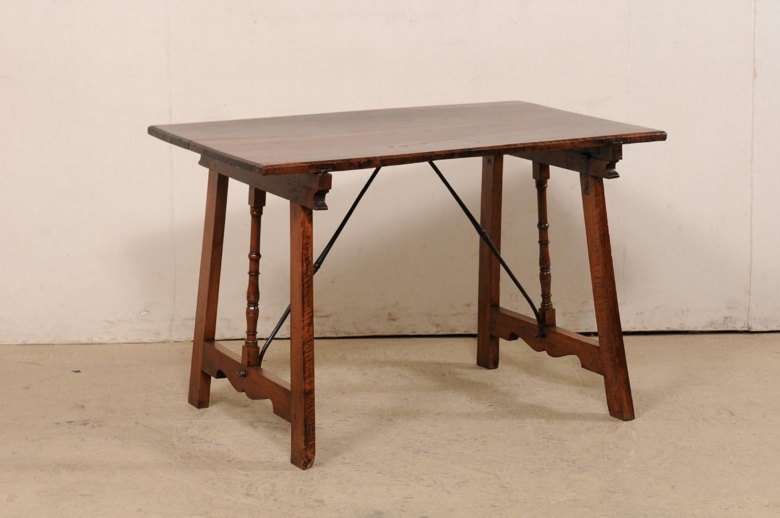 Ein spanischer Tisch aus geschnitztem Nussbaumholz mit Bahre aus dem 19. Dieser antike Tisch aus Spanien hat eine rechteckige Platte, die auf einem Paar gekippter Bockbeine im Sägebock-Stil ruht, die in der Mitte mit Spindelschnitzereien versehen