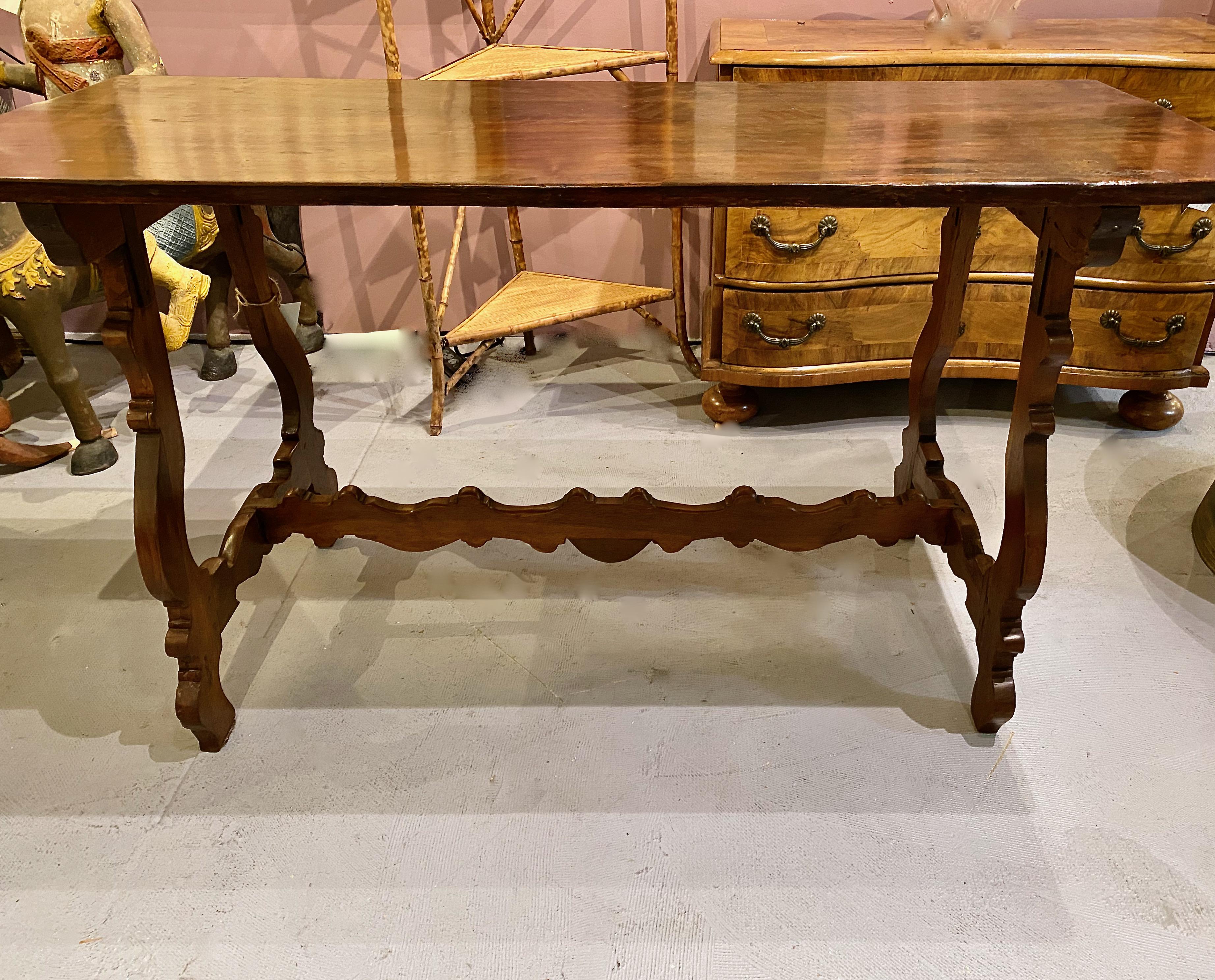 This is a charming small Spanish walnut trestle table that date to the late 19th or early 20th century. The table is in overall very good condition. It has been refinished and there are areas of old restoration which contributes to the table's