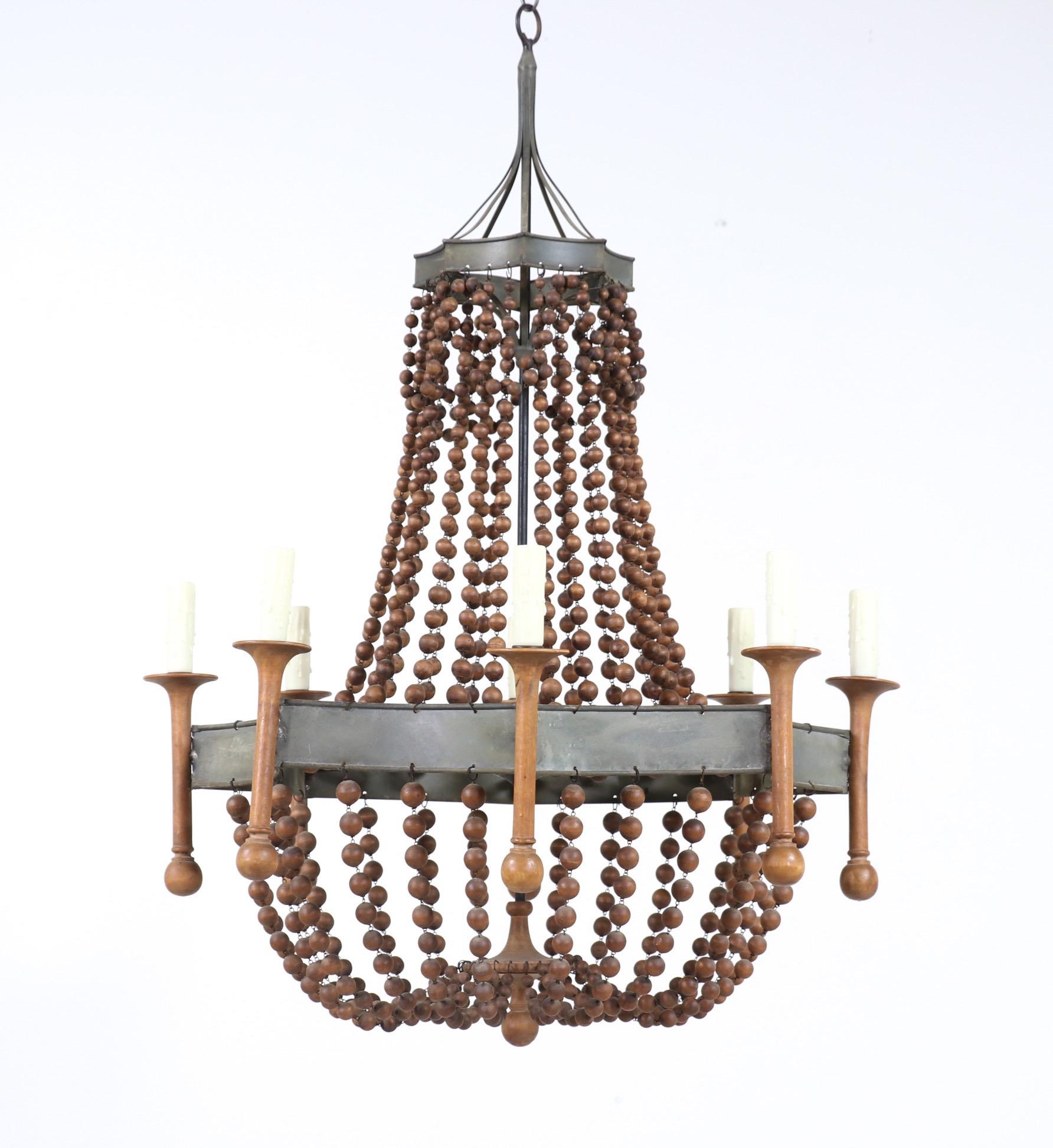 Impressive, 1960s Spanish wood beaded chandelier in the Empire style imported by Chapman Lighting.

Interior of chandelier is stamped: “Chapman, Made in Spain”. 

The chandelier consists of an octagon-shaped metal frame with strands of wood