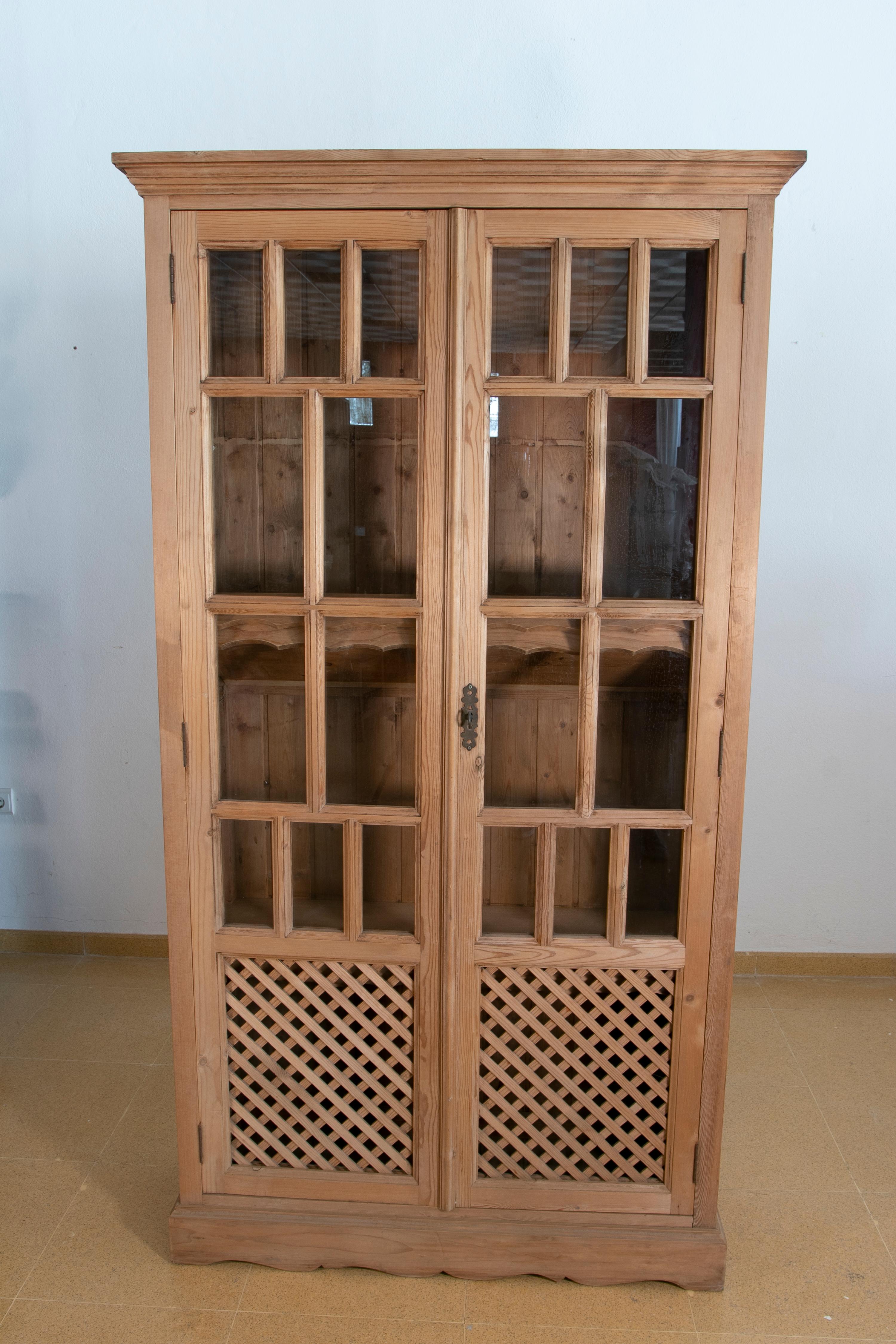 Armoire espagnole en bois avec portes vitrées et treillis.