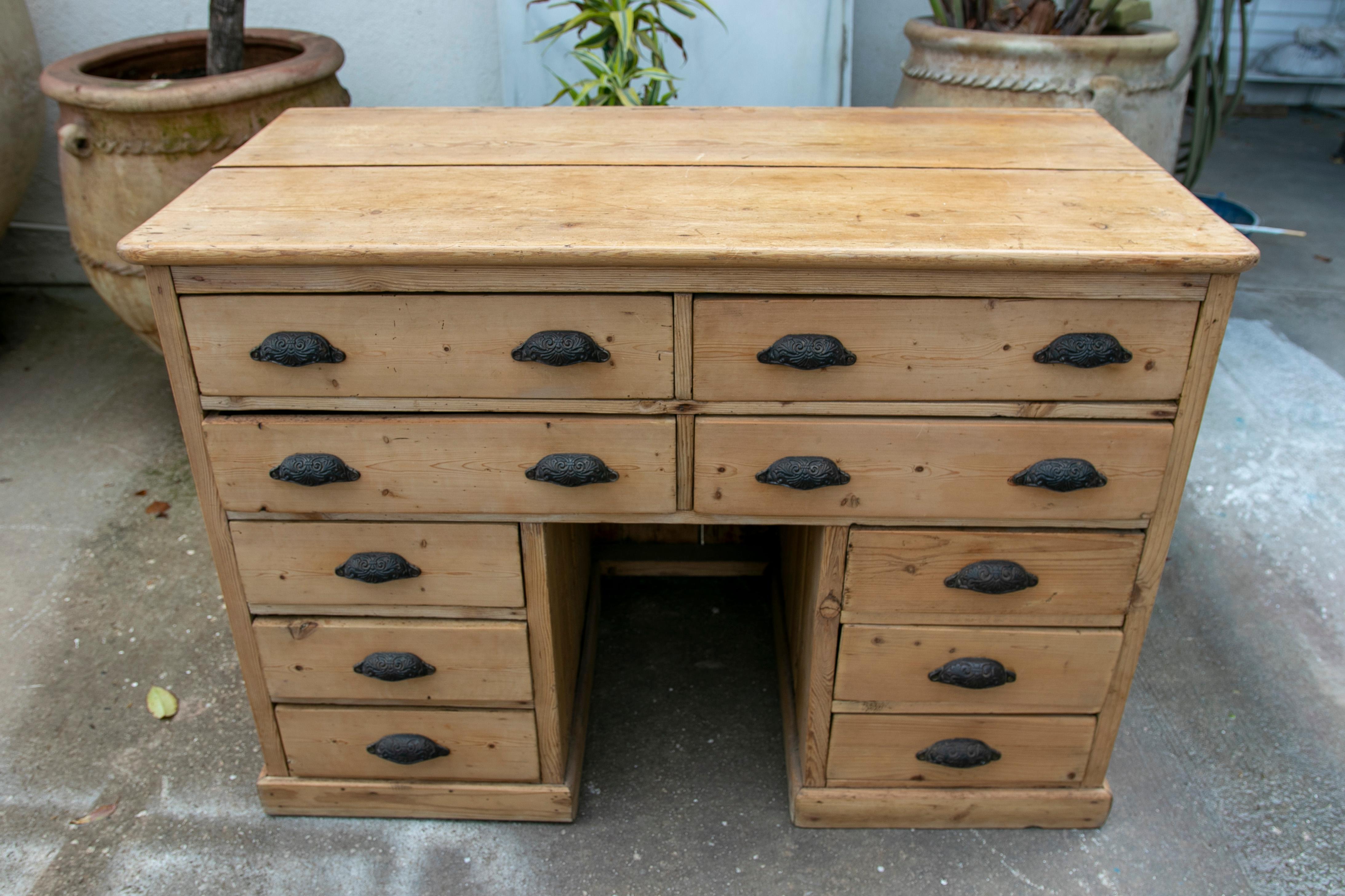 Spanish wooden desk with ten drawers and iron pulls.