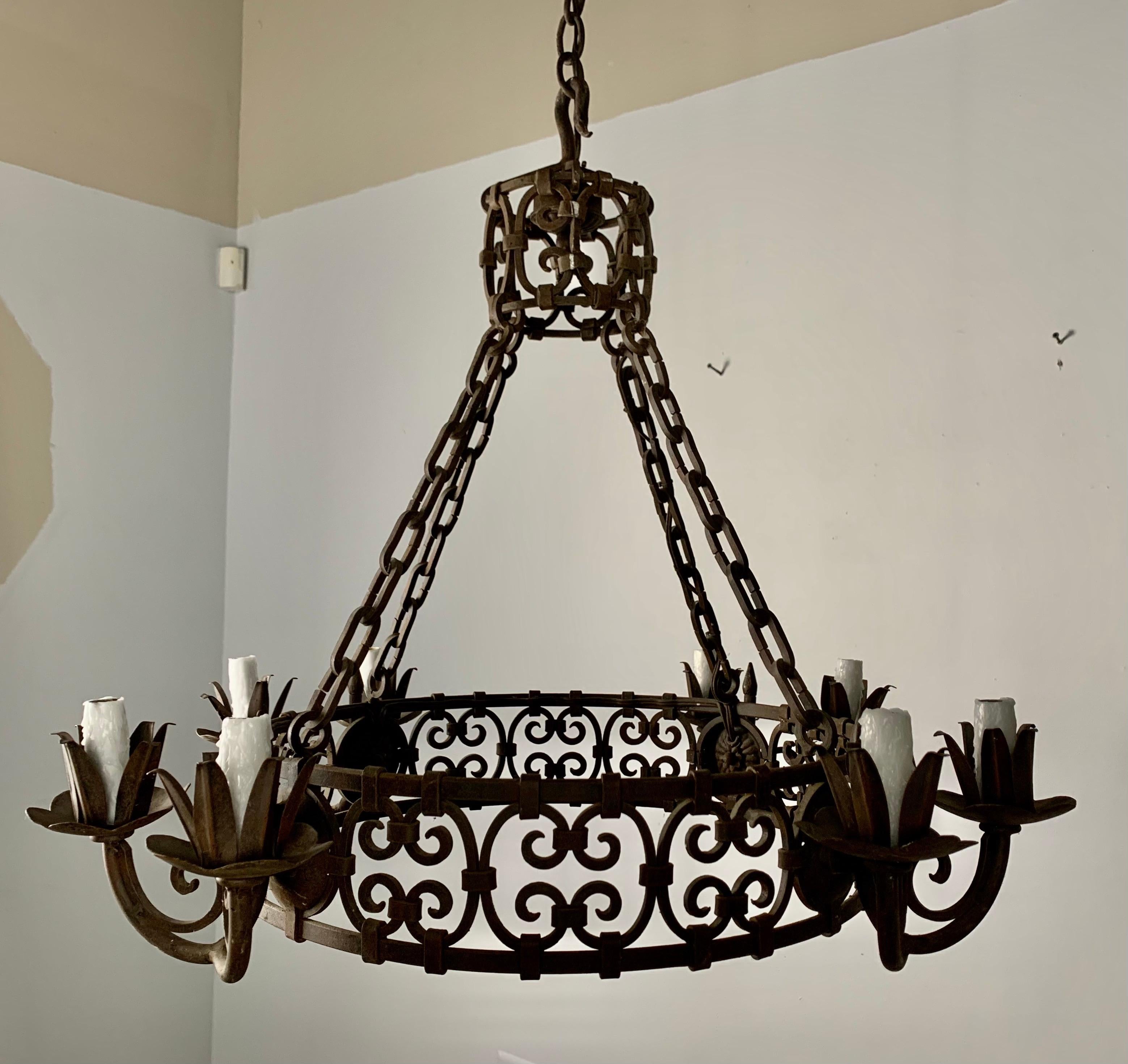 Spanish wrought iron 8-light chandelier with scrolled design. The chandelier is newly rewired with drip wax candle covers. It includes chain & canopy.