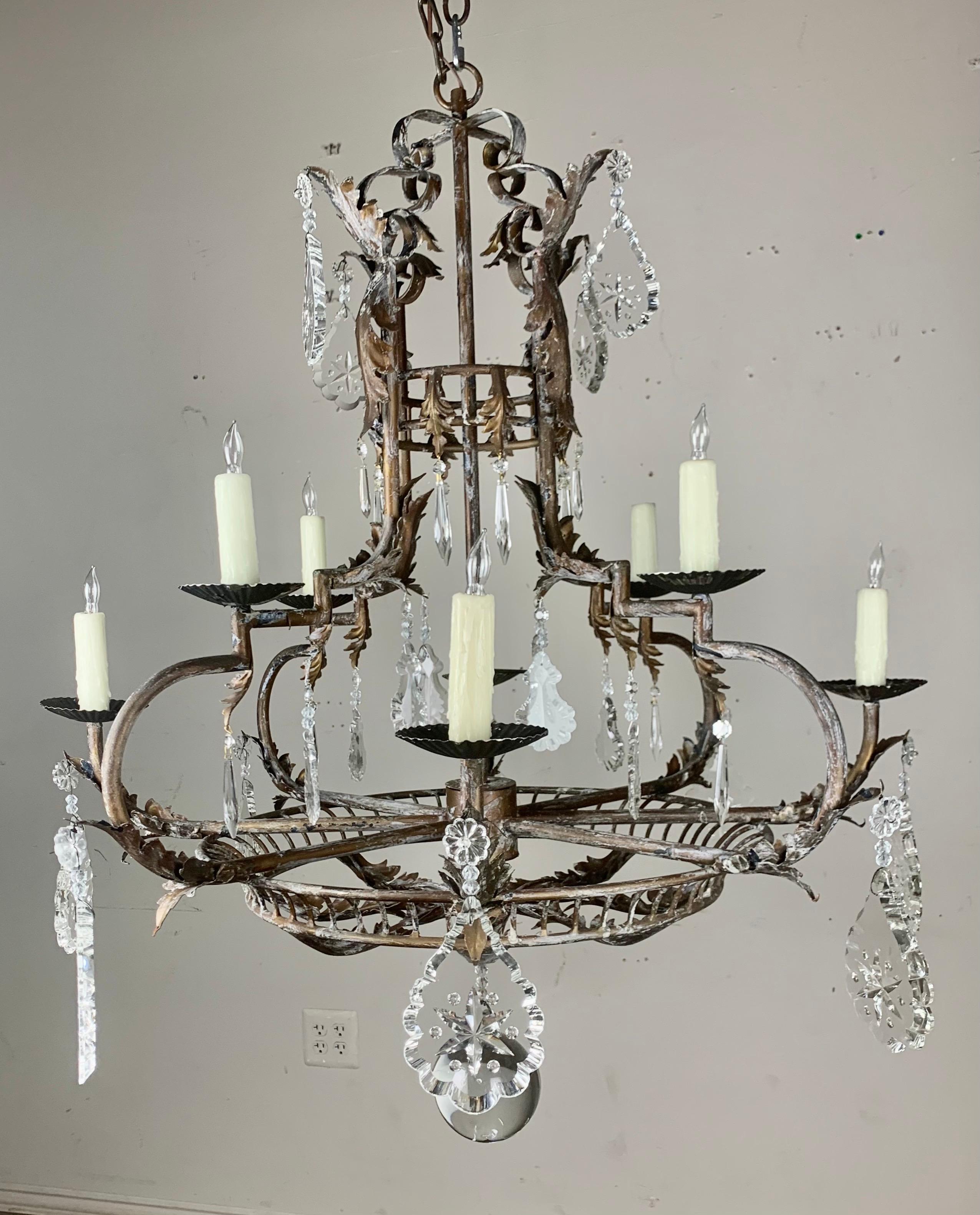 Spanish wrought iron eight light chandelier with etched crystals throughout. The fixture is newly rewired with drip wax candle covers. Chain & canopy included.
