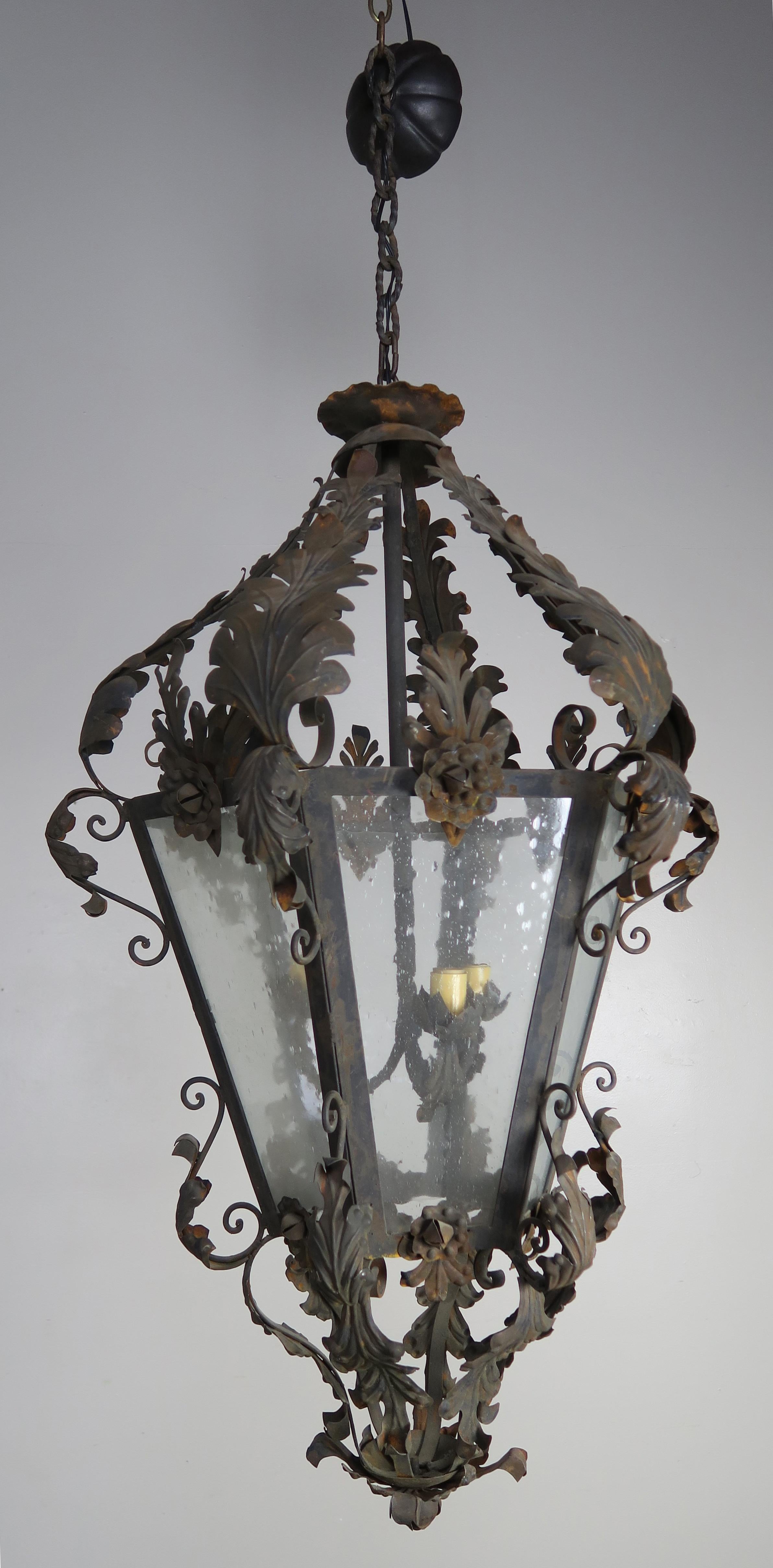 Spanish wrought iron and reeded glass 3-light lantern with acanthus leaves and roses though out. Original vintage finish.