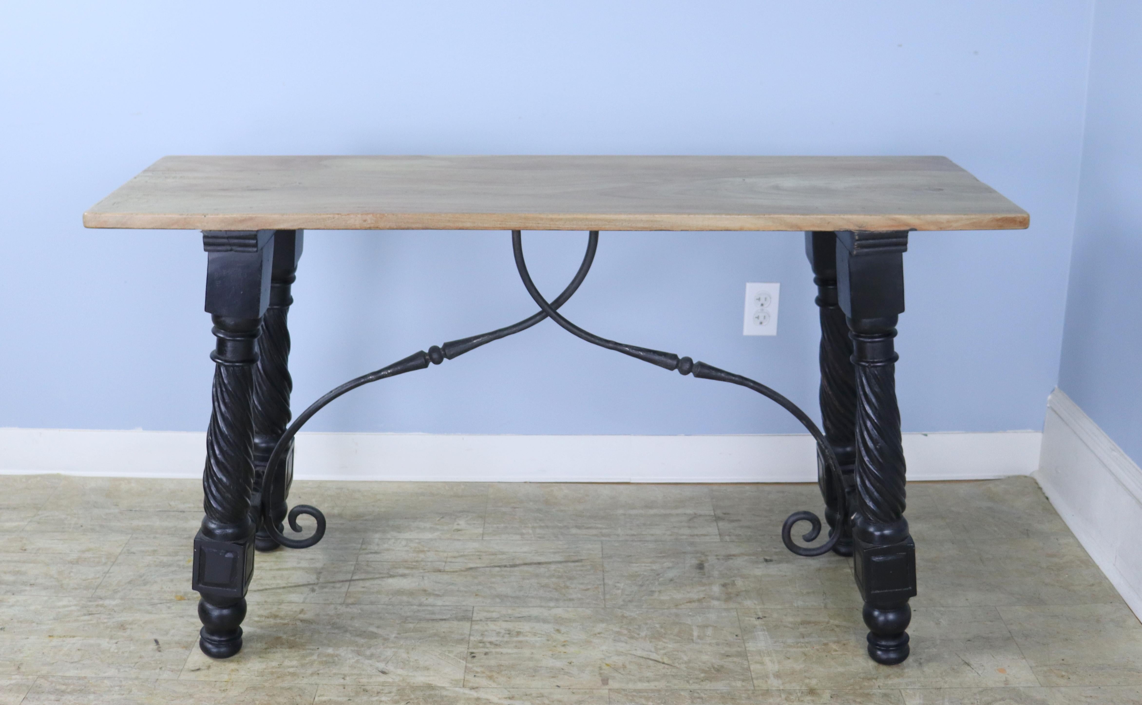 The oak top has been refinished on this interesting iron based table for a clean modern look. Great ebonized legs and curved iron supports. Good in the entryway or hall, or would be right as a sofa table.