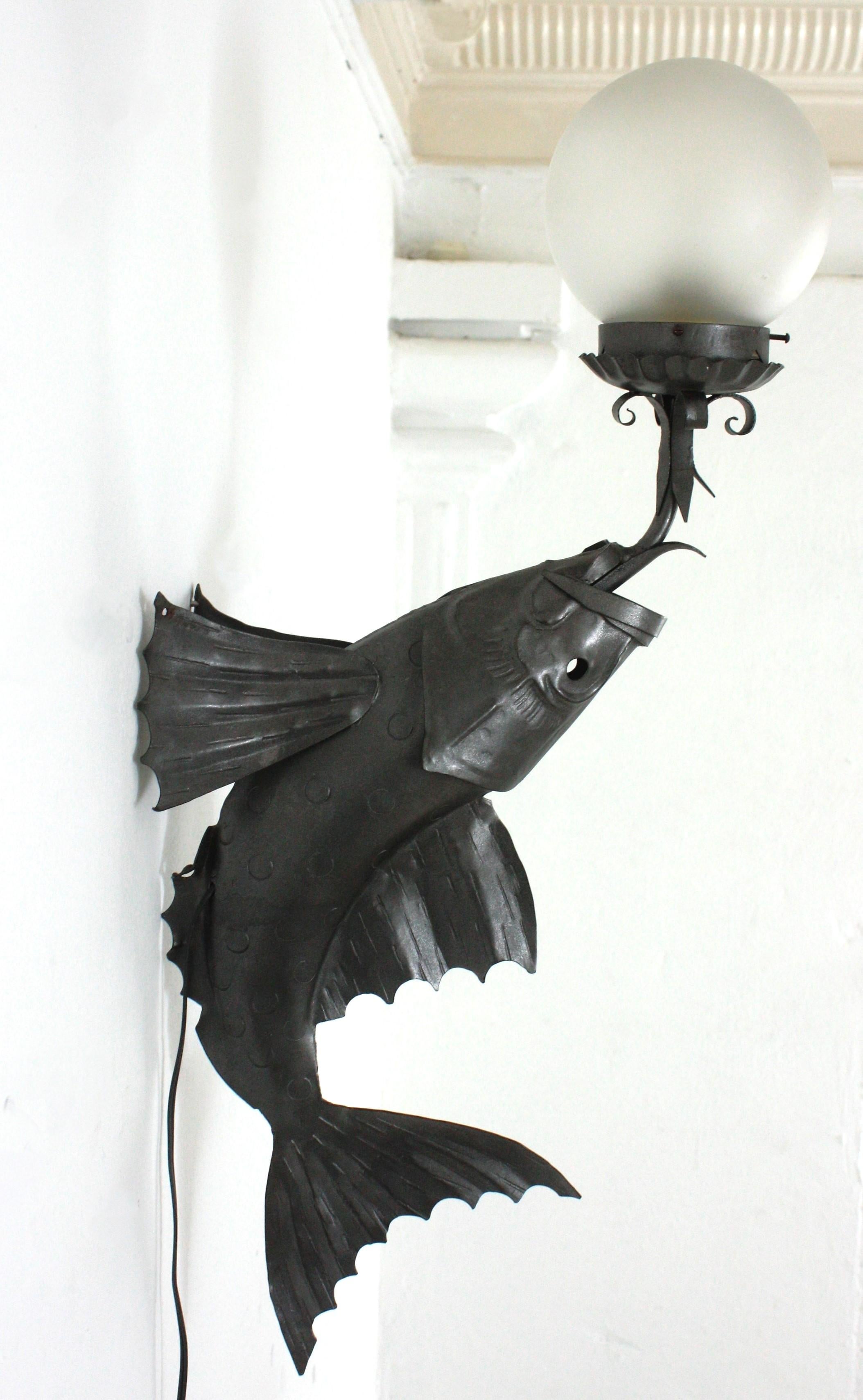 Spanischer schmiedeeiserner Fisch-Wandleuchter mit mattierter Glaskugel (Moderne der Mitte des Jahrhunderts) im Angebot
