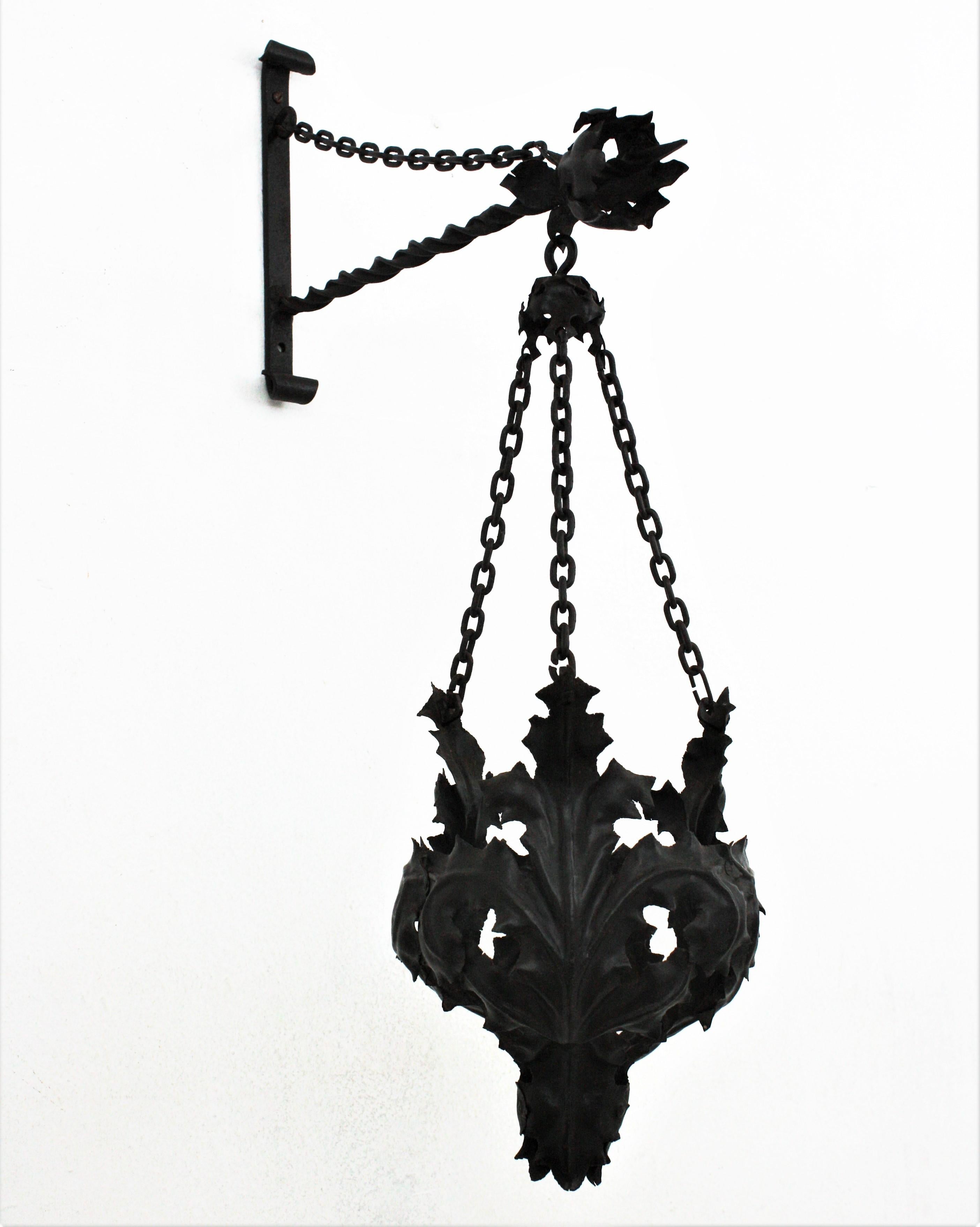 Eye-catching hand-hammered iron leafed wall hanging planter / basket in the style of Gothic, Spain, 1920s-1930s.
This hanging planter is all made by hand. The basket planter is made of iron leaves that hangs from three chains from a wall bracket