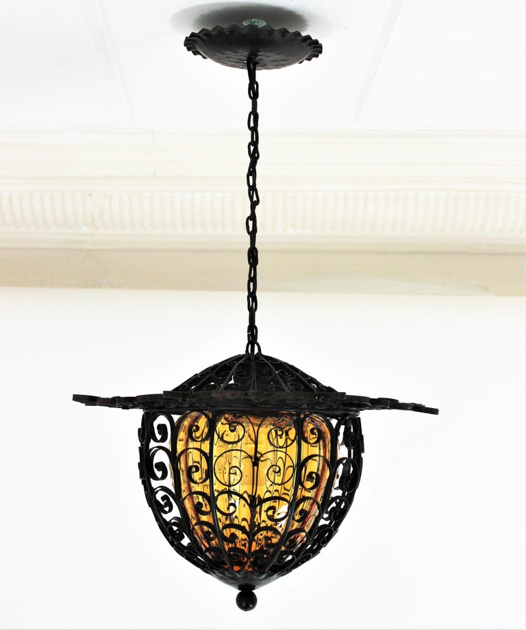 Spanish Lantern Pendant Light in Wrought Iron with Amber Blown Glass Shade For Sale at 1stDibs