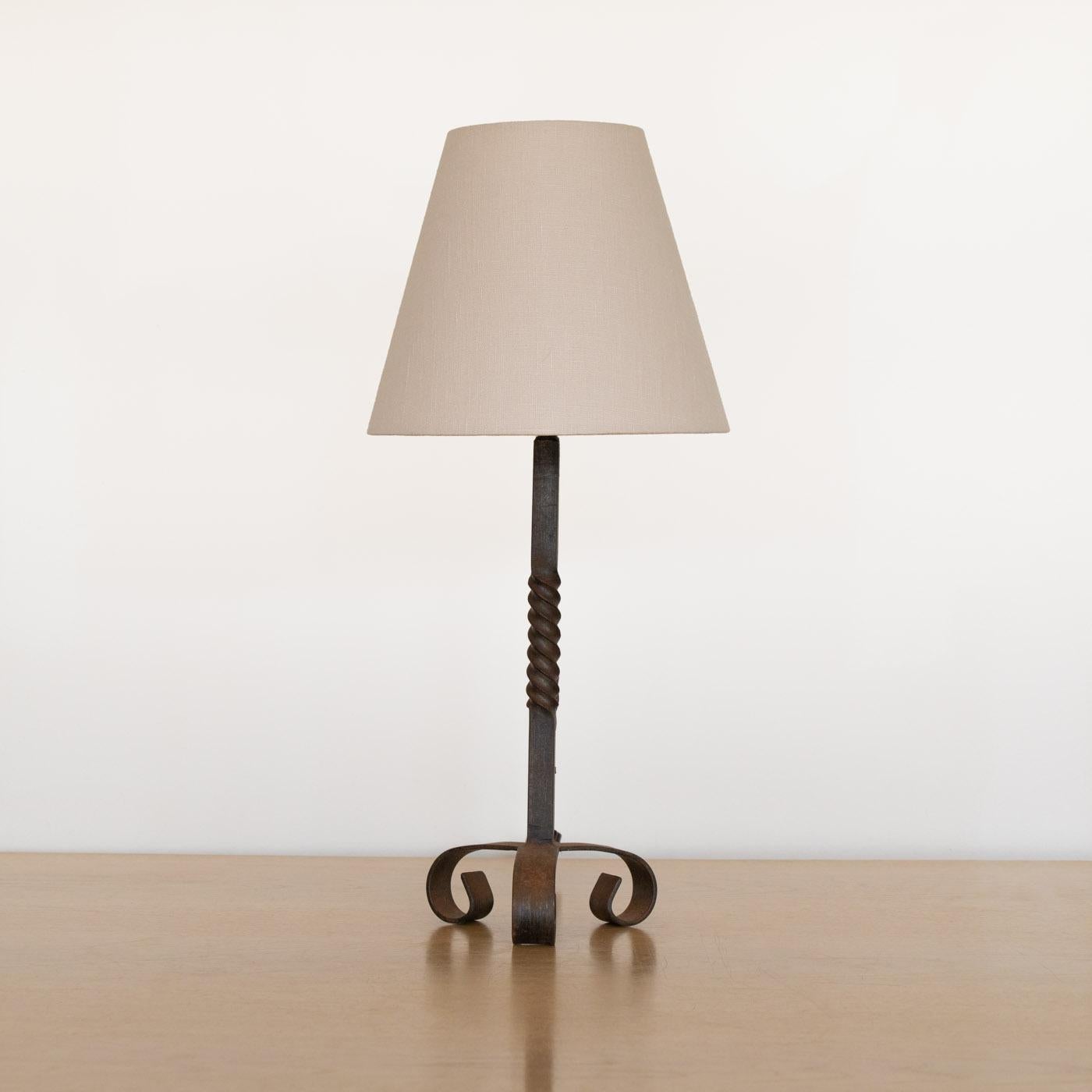 Beautiful Spanish wrought iron table lamp from the 1930's. Iron body with twisted iron base and three curved iron feet. Newly re-wired with new linen shade. Takes one E12 base bulb, 40 W or higher using LED.