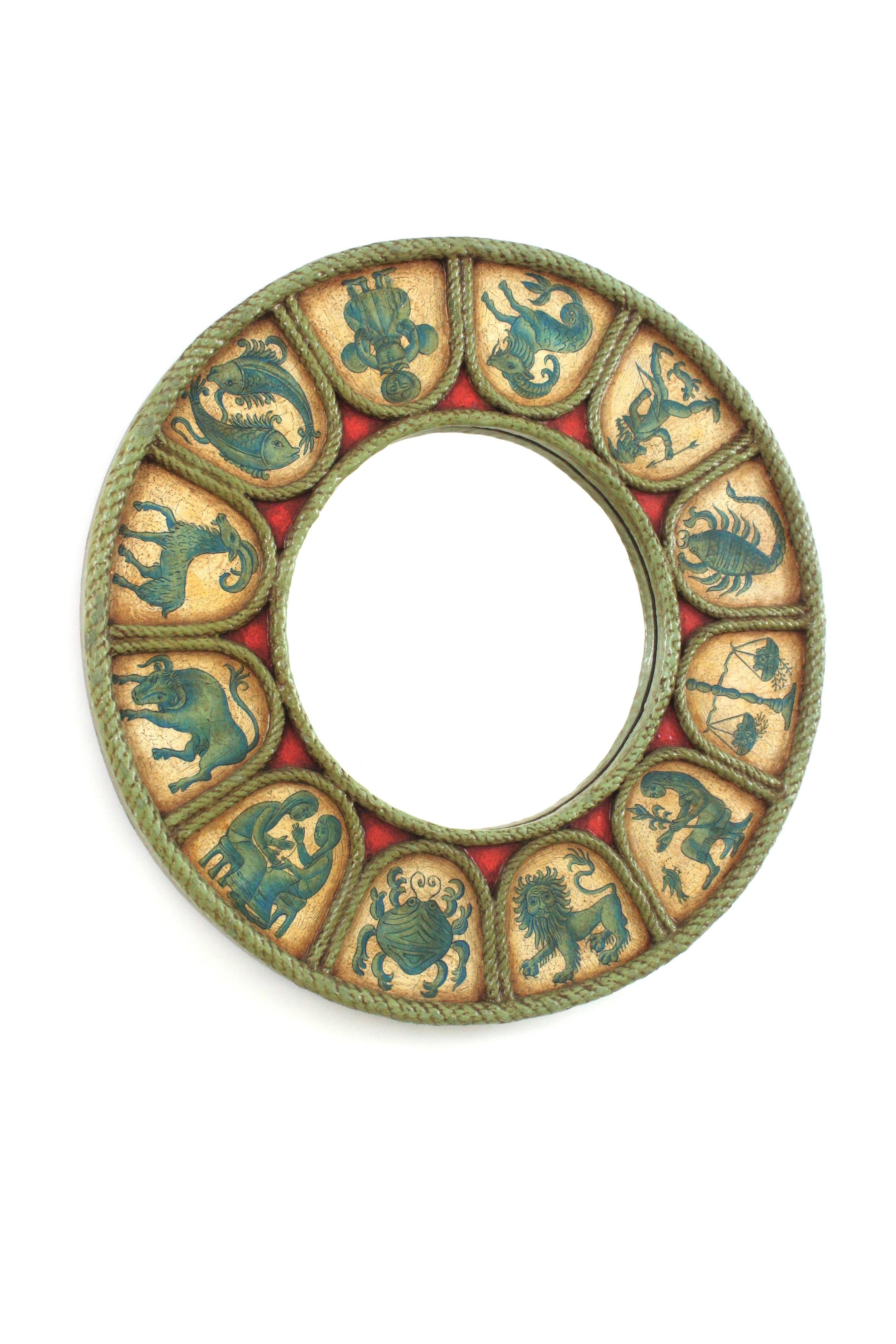 Zodiac sunburst round wall mirror in polychrome wood in turquoise blue, beige and red shades. Spain, 1950s-1960s.
Handcrafted Horoscope mirror with carved round frame and hand painted polychromed 12 signs of zodiac arround the frame. 
Sunburst
