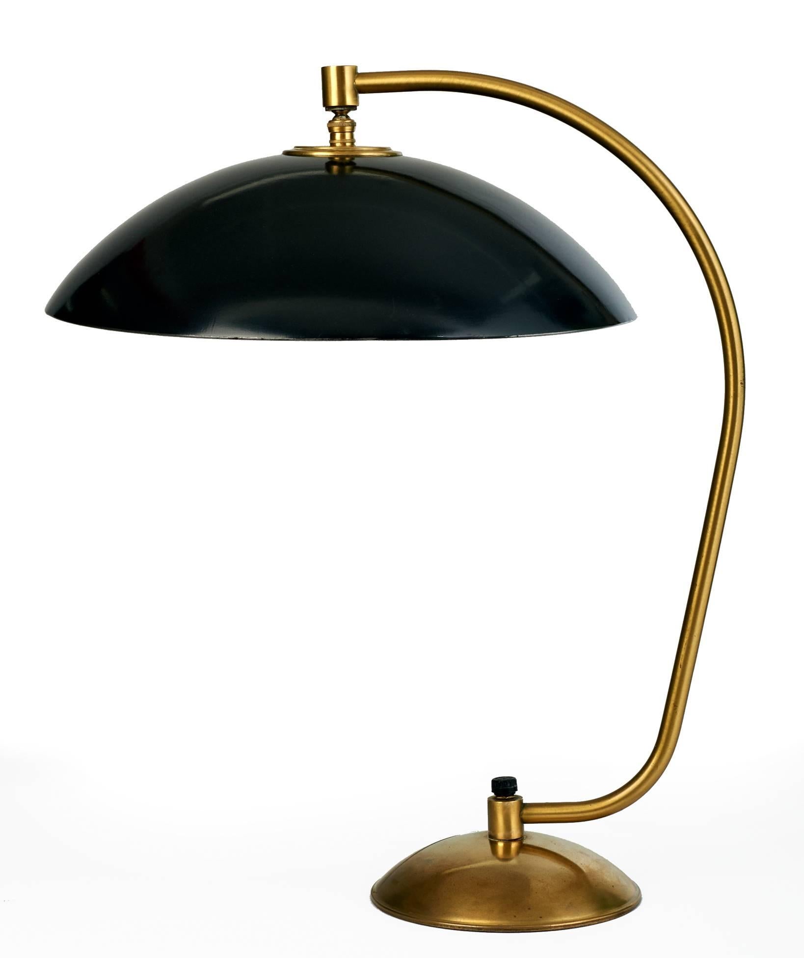 Kurt Versen (1901-1997)

Rare modernist enameled steel and brass table lamp by Kurt Versen. A curved shade, enameled in black with a white interior, overhangs a spare, sculptural tubular brass stem anchored by a rounded hemispheric base that subtly