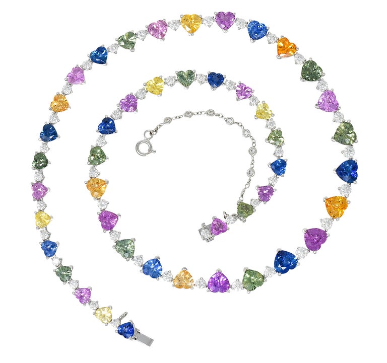 Link necklace features yellow, orange, green, pink, and blue heart cut sapphires 

Ranging from medium light to saturated in hue while weighing in total approximately 43.00 carats

With round brilliant cut diamonds weighing in total approximately