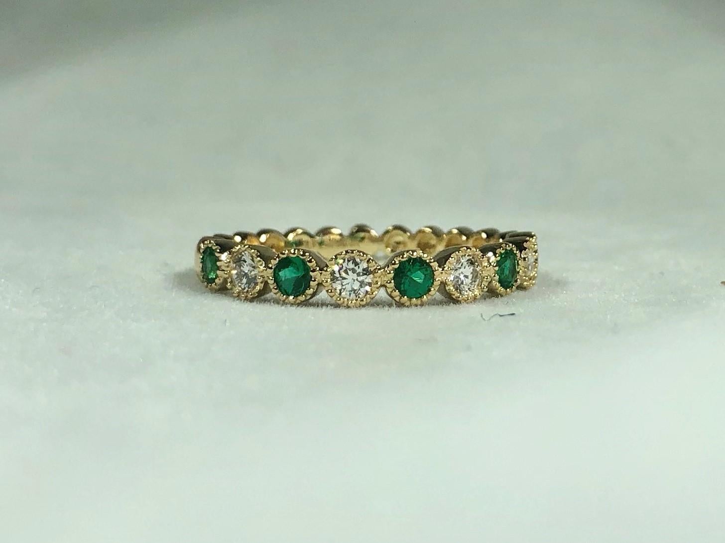 Spark Creations 18 Kt Diamond and Emerald Stacking Band. This Spark Creation is created in 18 kt yellow gold weighing,2.3 grams. This ring is adorned with 5 round Emeralds 0.25 carat total weight, and 4 Round diamonds 0.20 carat total weight.