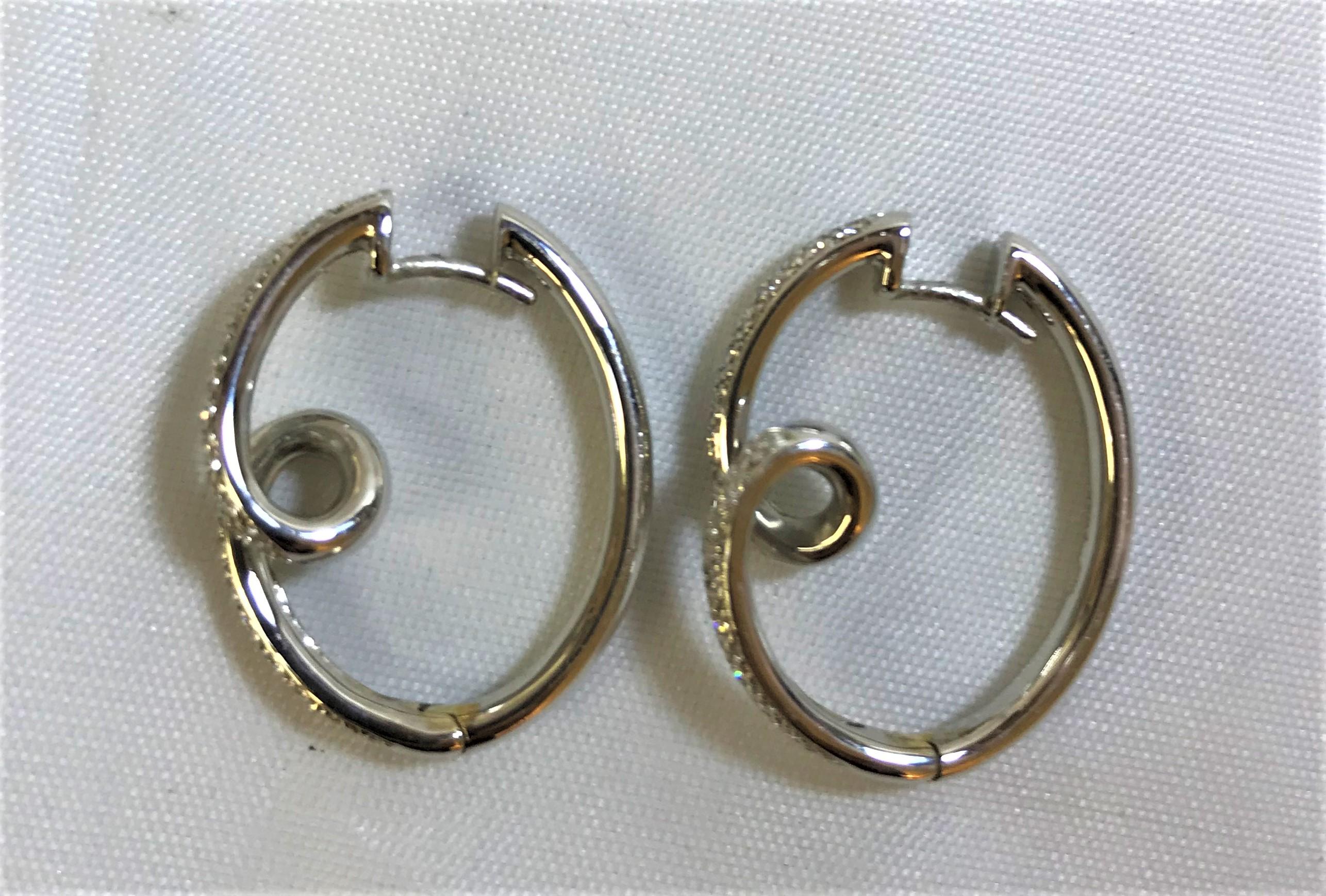 Beautiful hoop style earrings with a twist by Spark Creations.
18 karat white gold
36 round diamonds per earring (72 total diamonds)
Approximately .60 total diamond weight
Stamped 