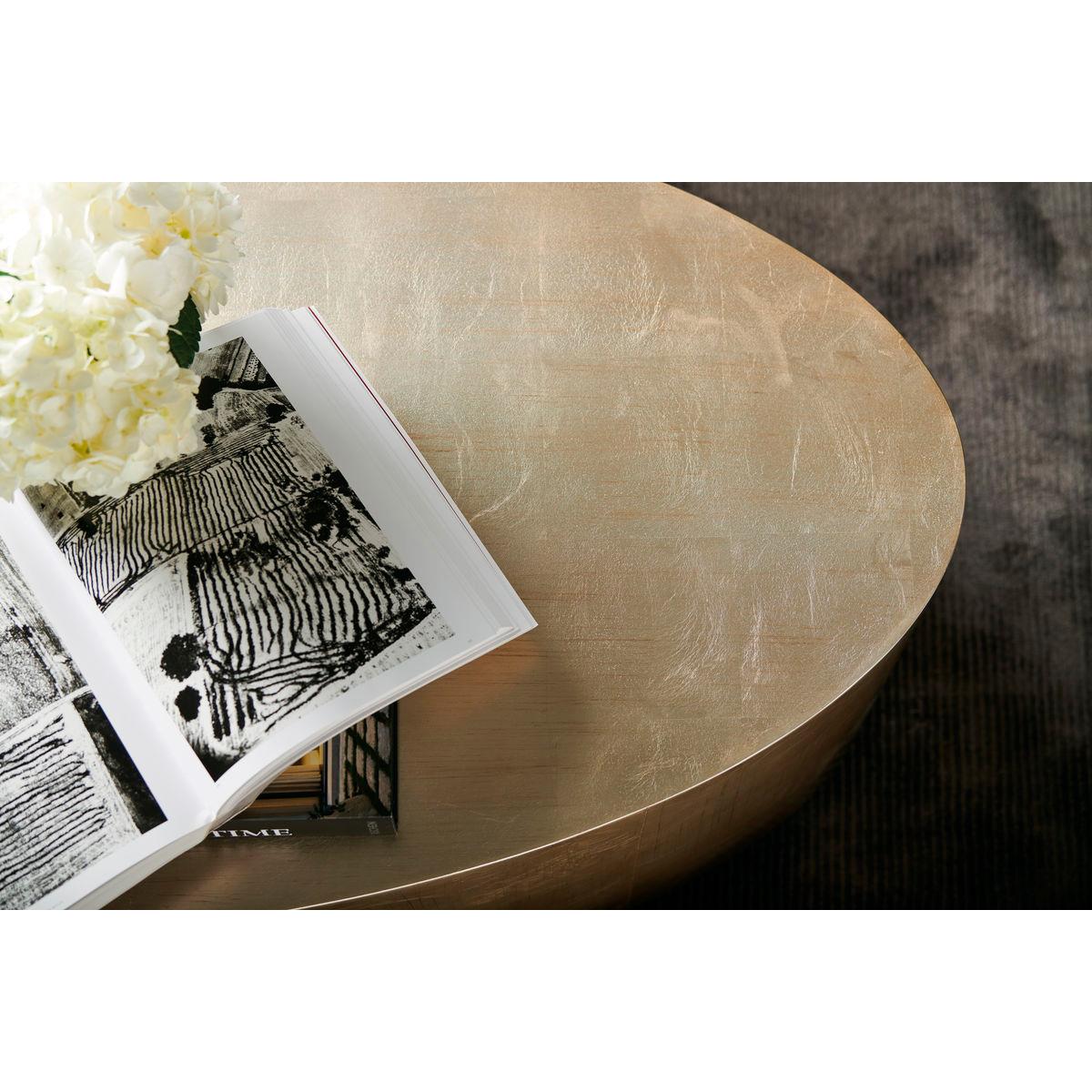 Not only does the oval shape encourage easy movement and flow around a seating area, this clever cocktail table adds such sparkle to a room.

Finished in a popular silver and gold leaf finish, and complemented by a rich Charcoal-finished base. A